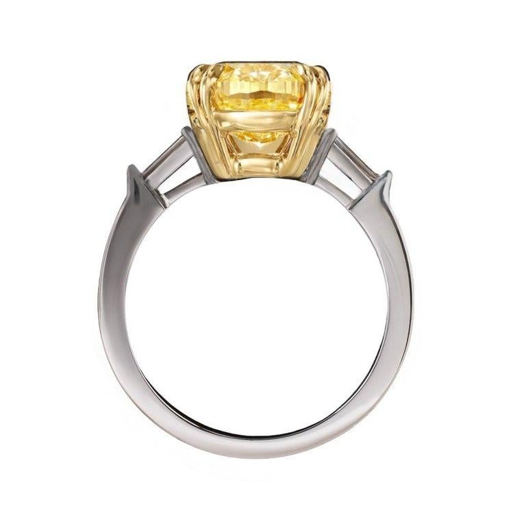 3 ct total weight oval cut natural fancy intense yellow diamond three-stone engagement ring is a stunning piece that combines platinum and 18K yellow gold. 

The centerpiece is a 3 ct natural oval cut diamond, fancy intense yellow color which