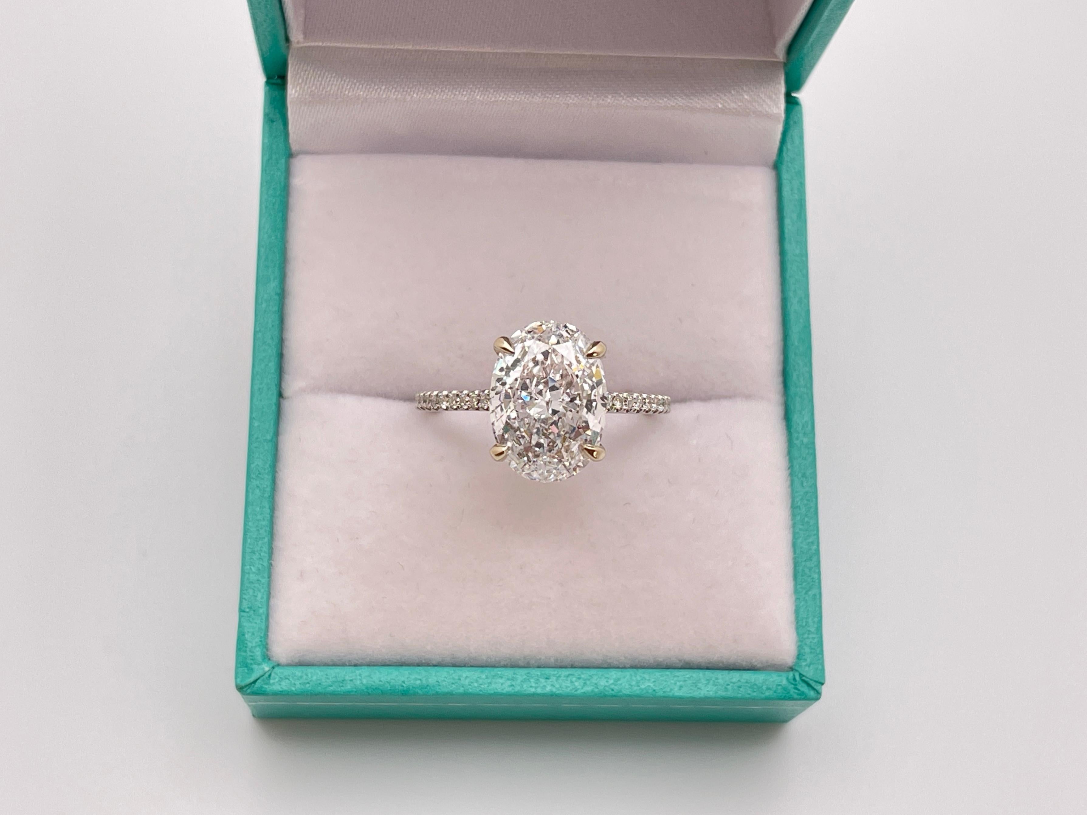 Un magnifico anello di fidanzamento con diamante in oro bianco 18K. Incastonato con uno splendido diamante naturale ovale taglio brillante da 3,01 carati, che mostra il raro e perfetto colore D, il più alto grado di bellezza incolore. Certificato