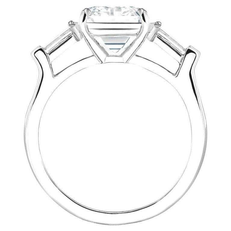 Presenting a 2.61 carat Emerald Cut Diamond Ring. This extraordinary centerpiece, certified by GIA, boasts D color and VVS1 clarity, perfectly proportioned with a coveted 1.50 length-to-width ratio—a hallmark of timeless elegance.

Flanked by two
