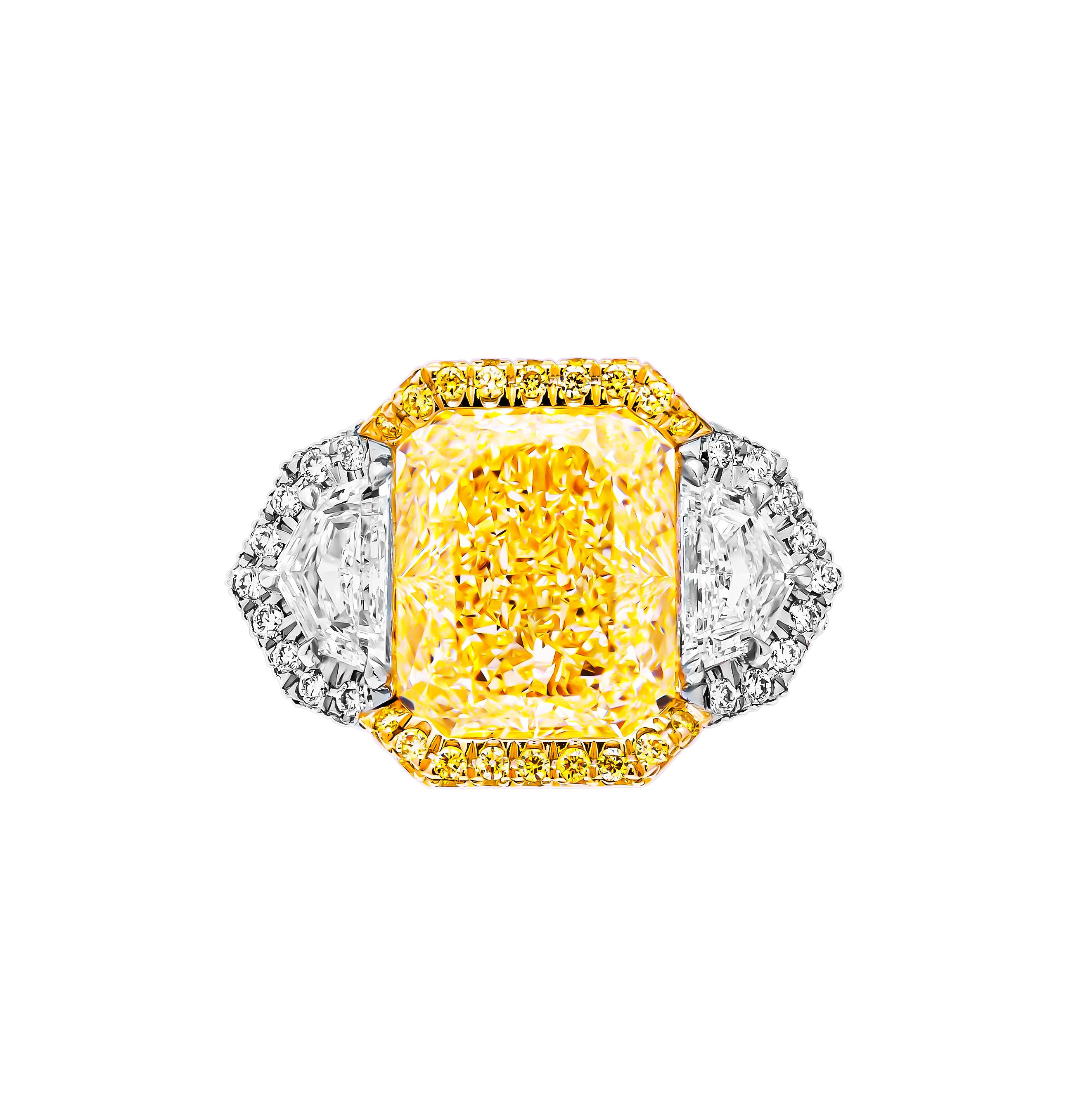 Indulge in the timeless elegance of this exquisite three-stone ring, crafted in a lustrous combination of 18K yellow gold and 950 platinum. At its heart lies a magnificent 7.06-carat natural fancy light yellow radiant diamond, ensconced in a sleek