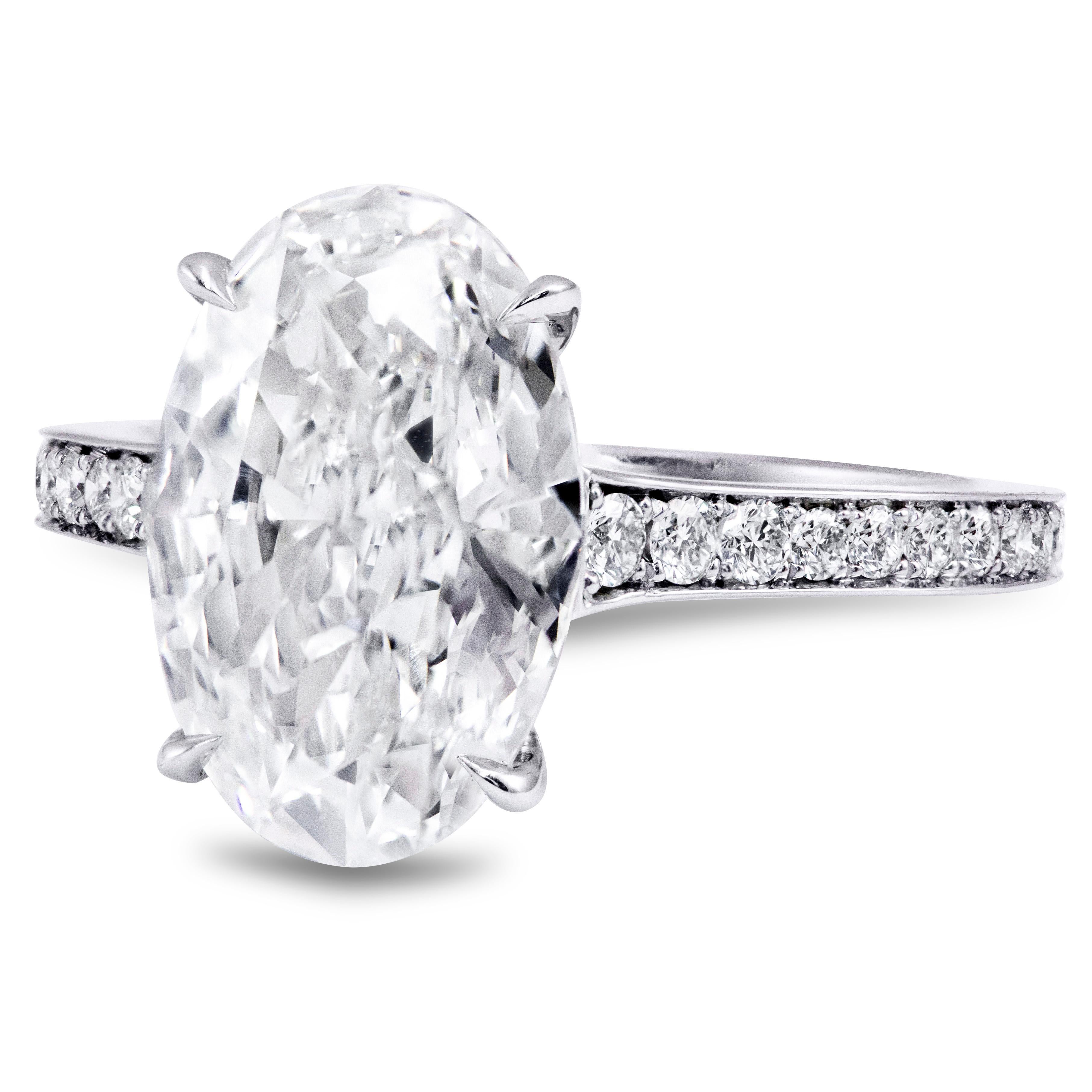 This classic but elegant engagement ring features a beautiful GIA certified 3.0 carats elongated oval cut center stone, set in a four prong basket setting and diamond encrusted platinum composition weighing 0.26 carats total. Finely made in Platinum