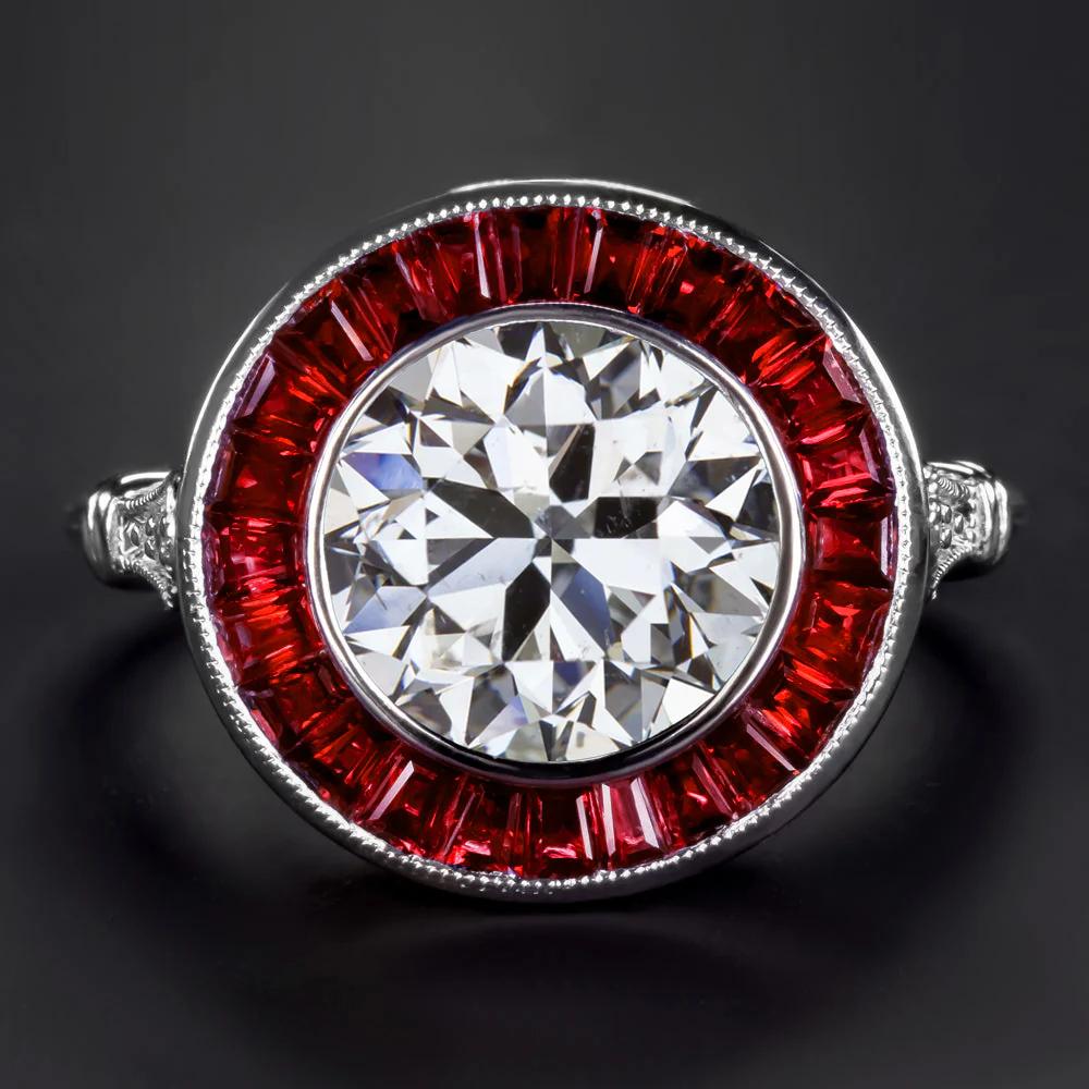 Questo anello mozzafiato in stile Art Déco presenta uno splendido diamante rotondo taglio brillante da 3,00 carati certificato da GIA, circondato da una vivida aureola di rubini naturali taglio calibro. Il diamante è classificato di colore H e