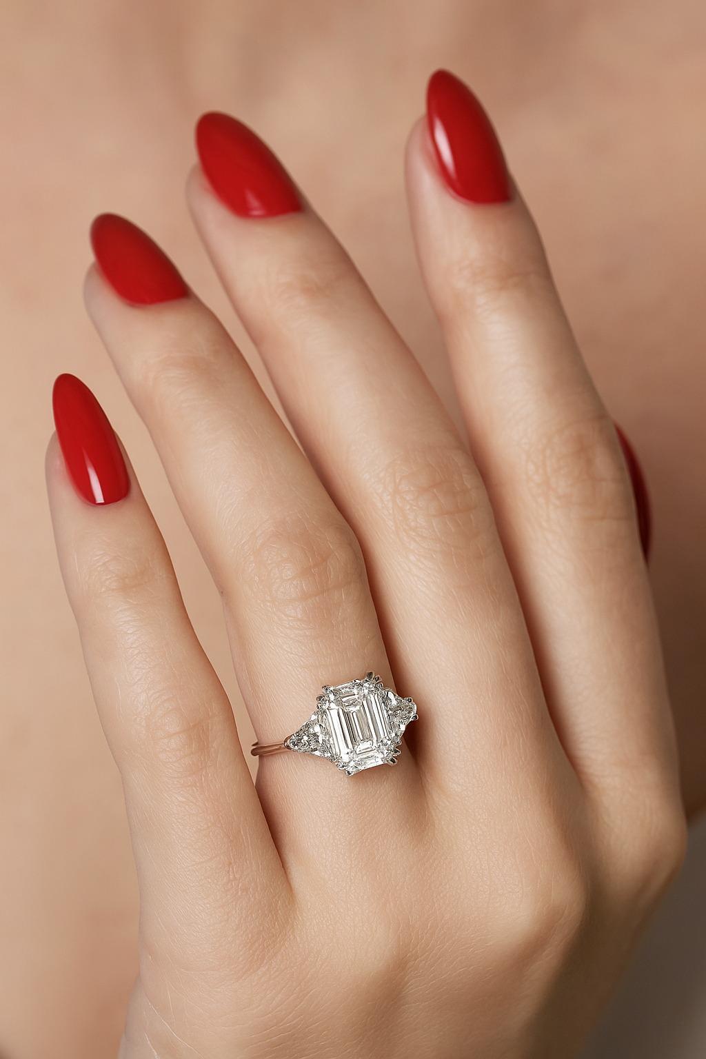 Questo anello, un capolavoro senza tempo, è incentrato su un diamante con taglio a smeraldo da 3,01 carati, certificato GIA.  colore G e purezza VS2. Con dimensioni di 9,96 × 7,11 × 4,73 mm, il diamante mostra una silhouette splendidamente allungata