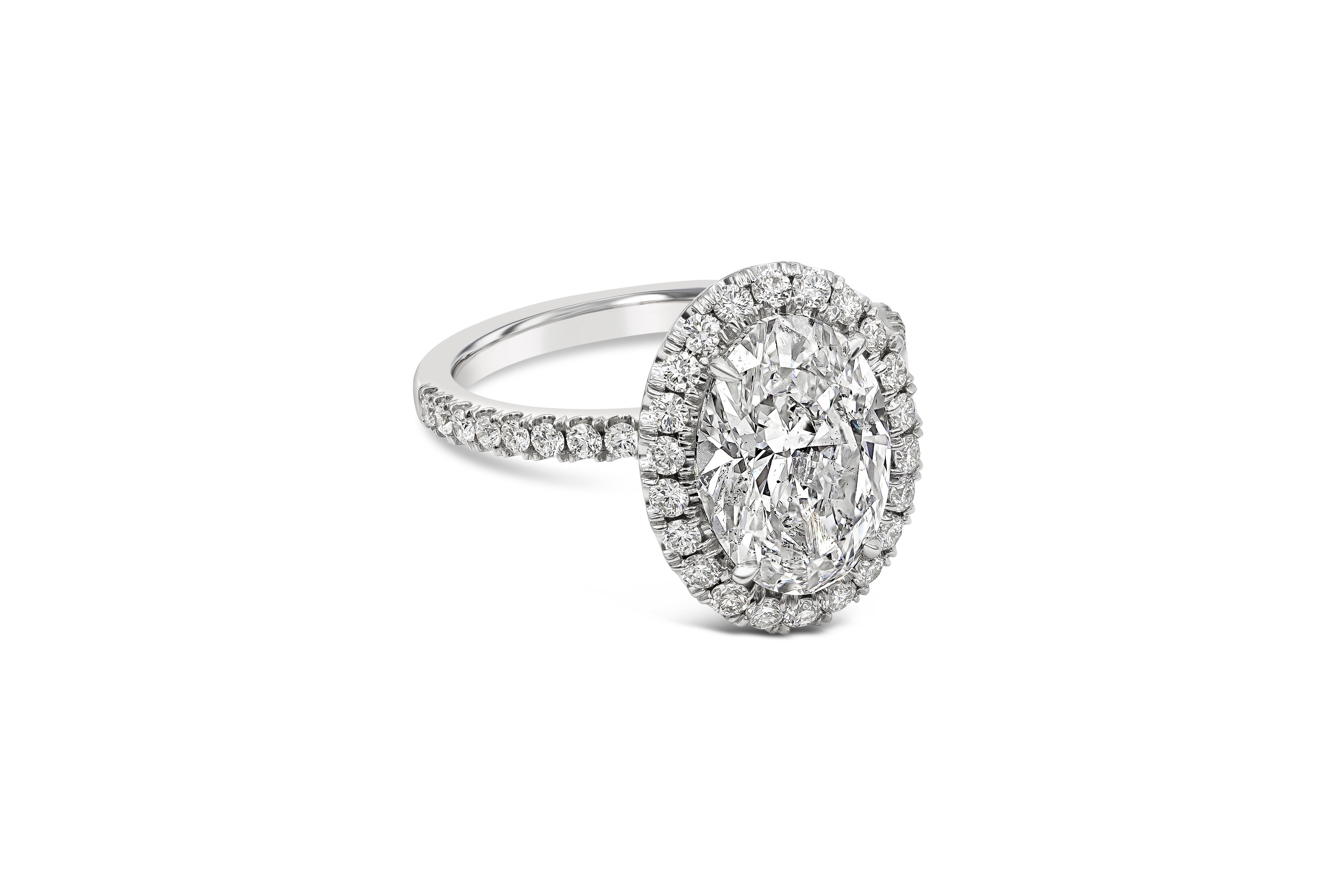 A classic engagement ring style showcasing a 3.01 carats oval cut diamond certified by GIA as G color, SI2 clarity. Surrounded with brilliant round diamonds in seamless halo setting. Shank is diamond encrusted in half eternity setting finely made in