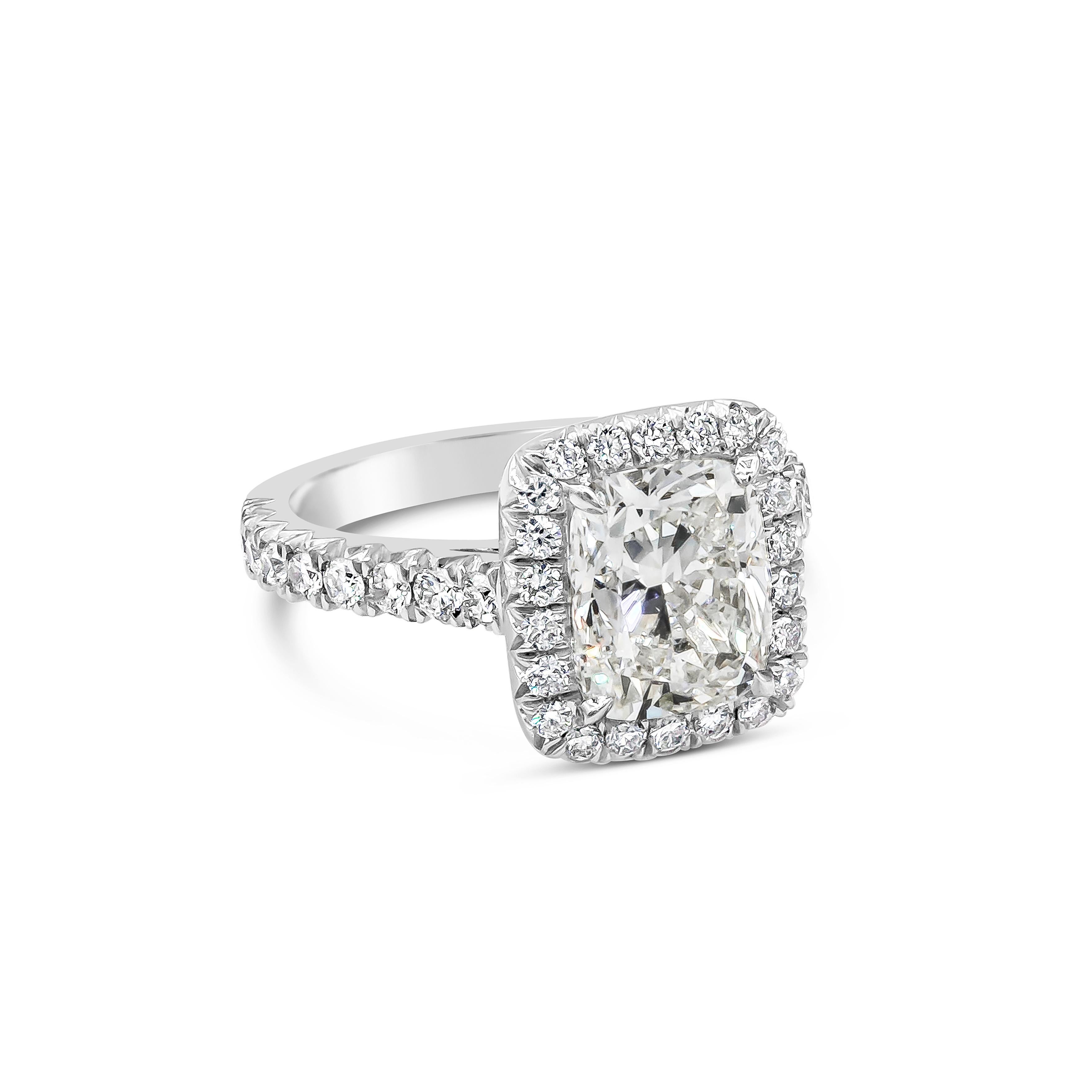Features a 3.02 carats cushion cut diamond certified by GIA as J color and VS2 in clarity, surrounded by a single row of round brilliant diamonds in halo pave setting. Set in a platinum band with accented round diamonds in half-eternity setting.