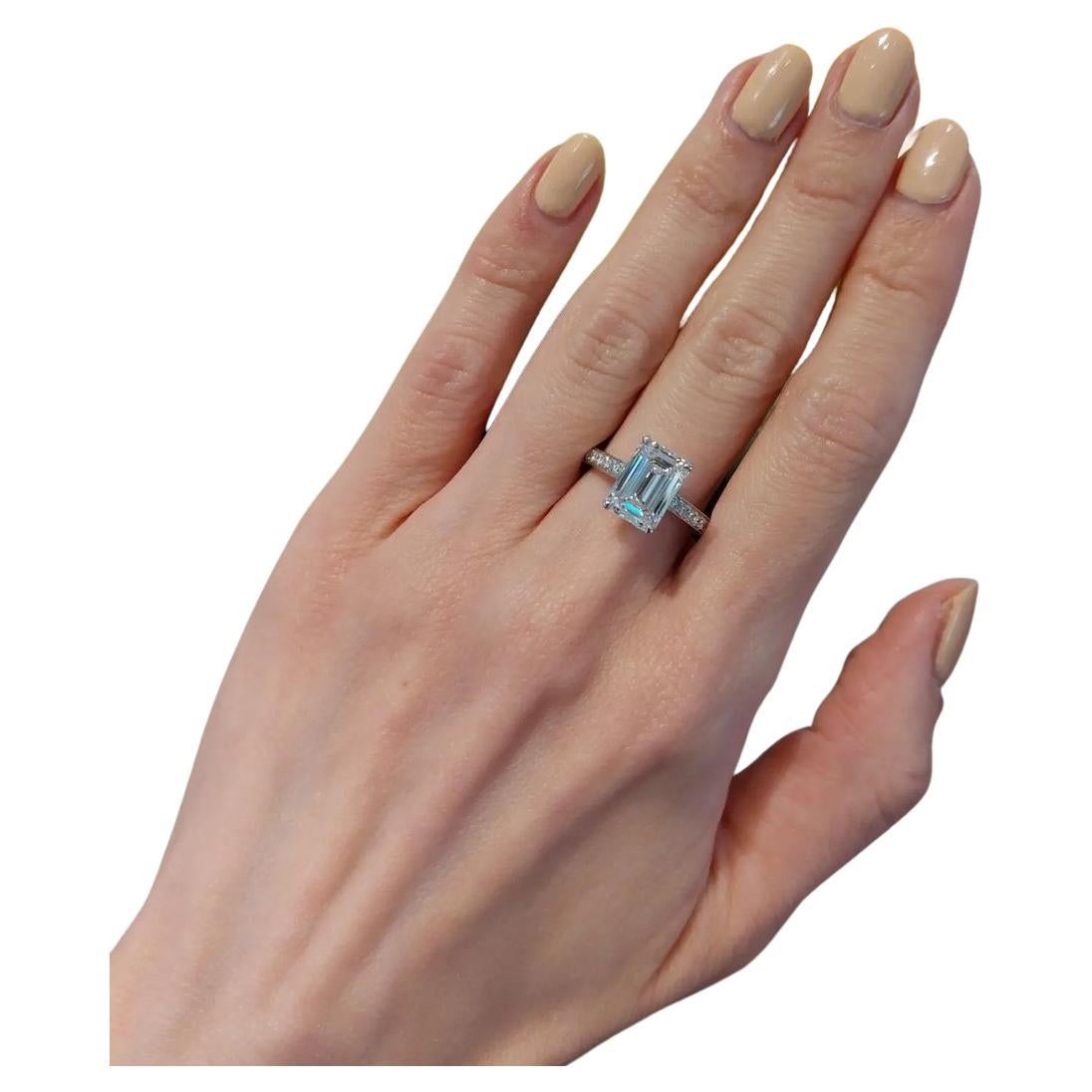 Presentamos un impresionante Anillo de Compromiso de Platino con Diamante de Corte Esmeralda de 3.02 Quilates Certificado por el GIA, adornado con delicados pavés de diamantes a lo largo de la banda, que elevan su encanto a nuevas cotas. Este