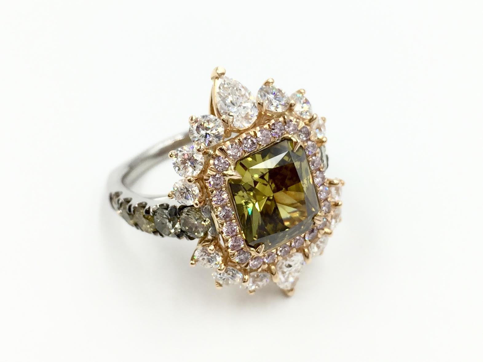 A beautifully unique platinum and 18k rose gold diamond cocktail ring. A 3.02 radiant cut G.I.A. certified Fancy Deep Brown-Greenish Yellow, SI2 diamond is set with a halo made of 18k rose gold and .28 carats of pink diamonds. The halo is surrounded