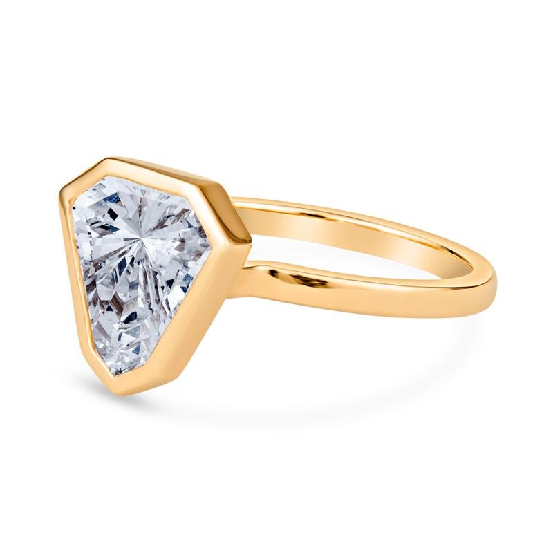 This is a very unique engagement ring featuring a 3.02 carat, I SI2,  modified shield cut diamond that is bezel set in 18 karat yellow gold. It is a size 6 but can be resized upon request. This ring will shine on your finger and receive many