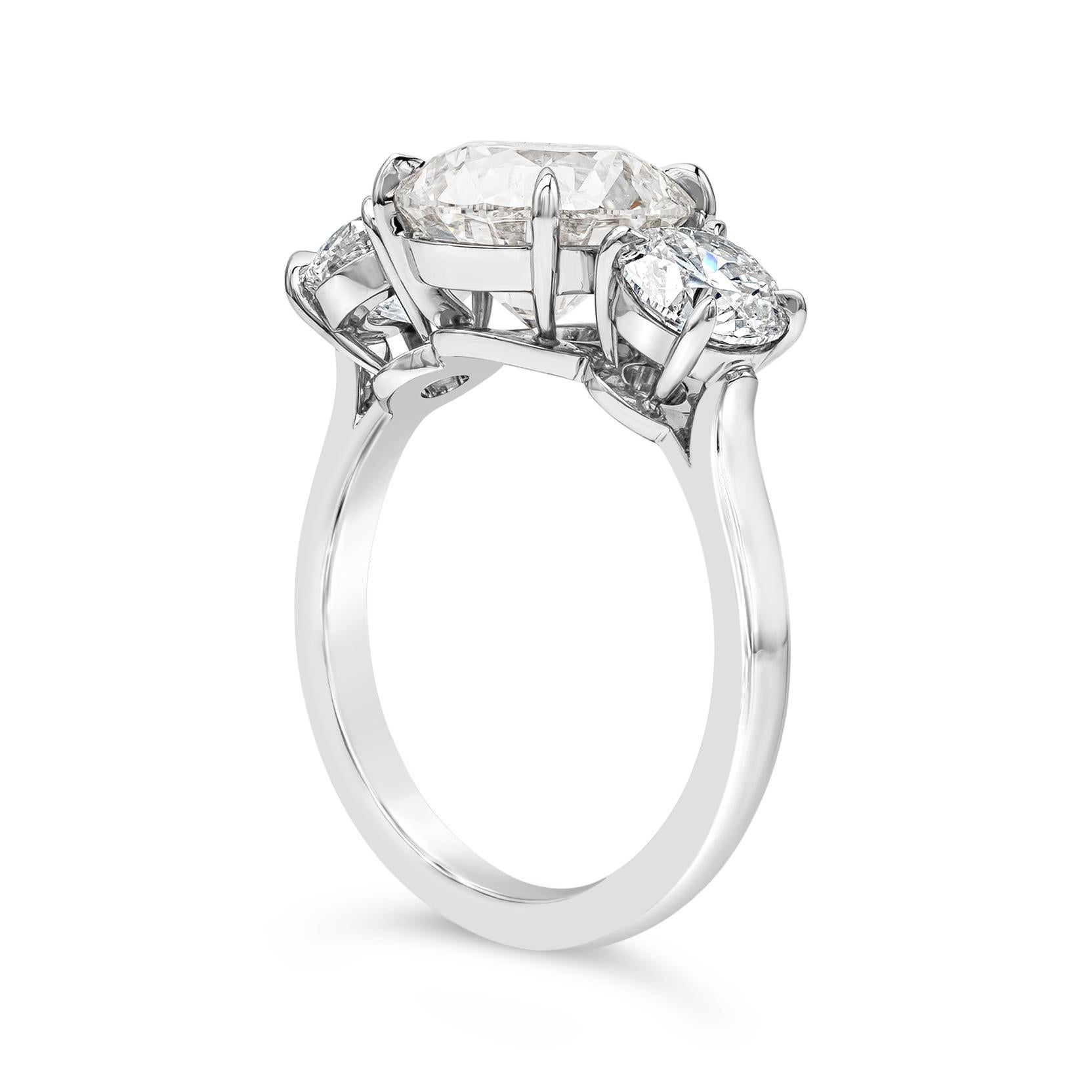 This classy and simple three stone engagement ring showcases a 3.02 carats brilliant round diamond certified by GIA as G color and SI2 in clarity, set in a four prong basket setting. Flanked by round brilliant diamonds on each side weighing 1.40
