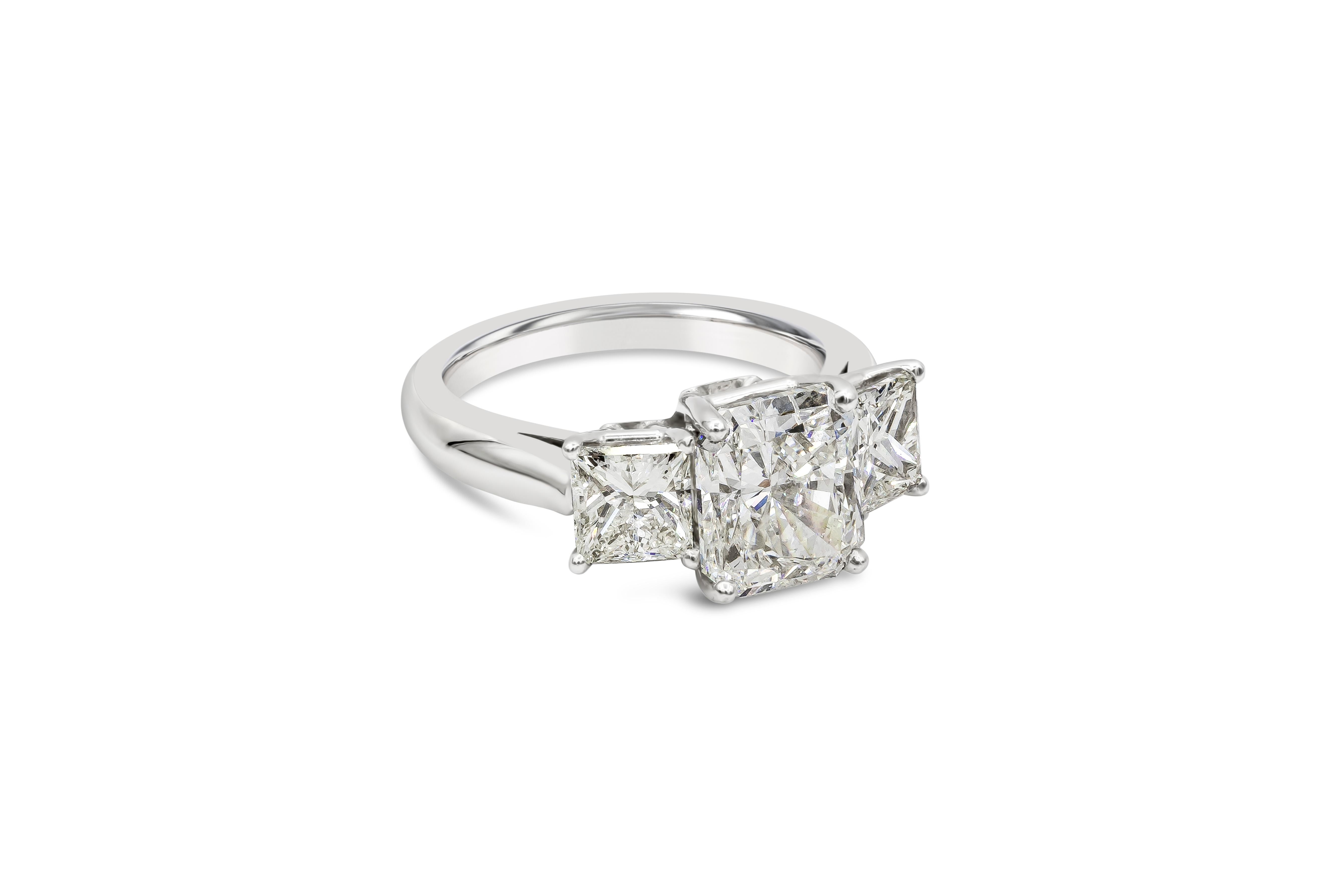 A classic and brilliant engagement ring style showcasing a 3.03 carat radiant cut diamond certified by GIA as I color, VS1 clarity. Flanking the center are princess cut diamonds weighing 1.60 carats total. Set in a polished platinum mounting. Size 6