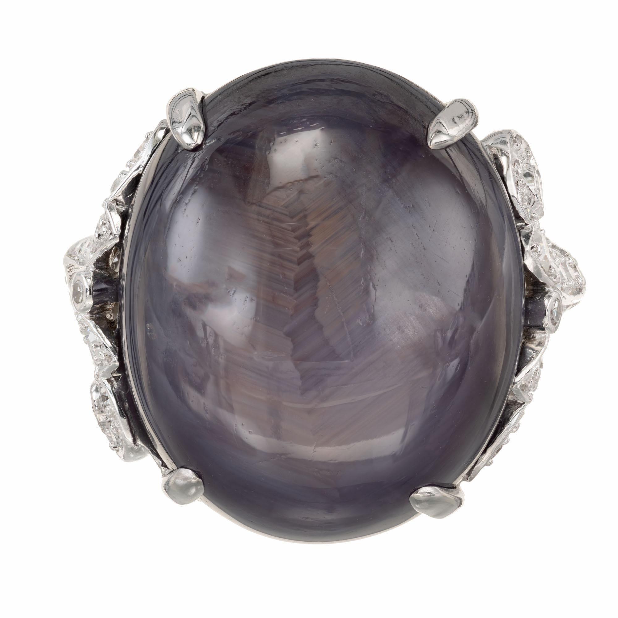 Vintage purple natural 30.37 carat oval star sapphire and diamond engagement ring. GIA certified platinum setting with a star sapphire cabochon center stone, accented with 40 single cut diamonds. Minor natural surface abrasions. 

1 oval cabochon