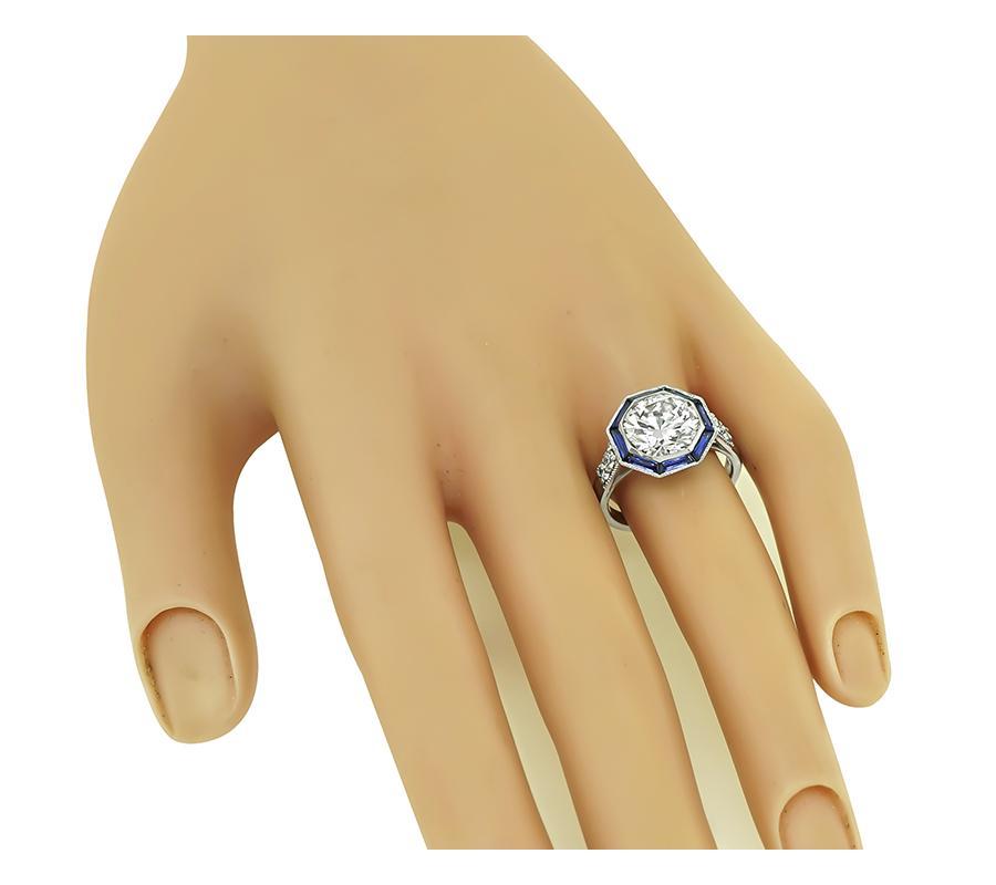 This is a fabulous platinum engagement ring. The ring is centered with a sparkling GIA certified round brilliant cut diamond that weighs 3.03ct. The color of the diamond is K with VS1 clarity. The center diamond is accentuated by lovely sapphire and