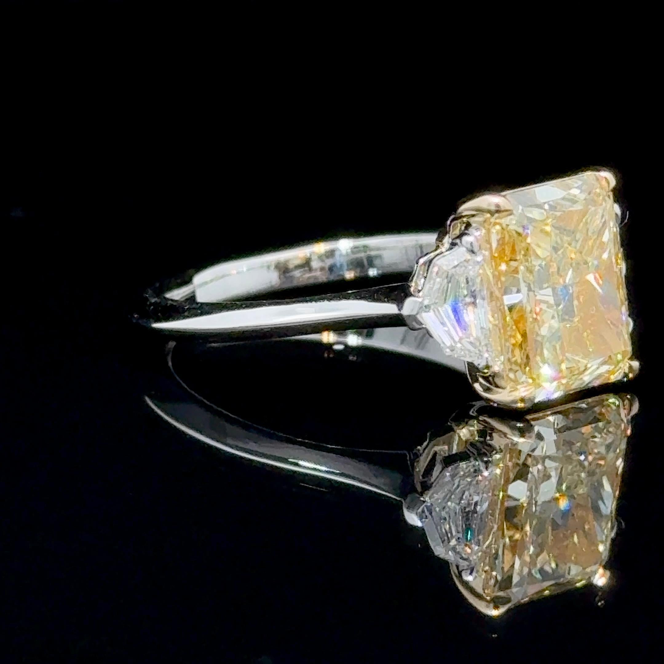 A perfectly cut GIA Certified 3.04 Carat Radiant Cut Fancy Yellow Diamond Three Stone Ring.
Featuring a GIA Graded 3.04 Rectangular Radiant Cut, Fancy Yellow, VS2 Clarity.
Excellent Polish, Excellent Symmetry, No fluorescence. Length to Width Ratio:
