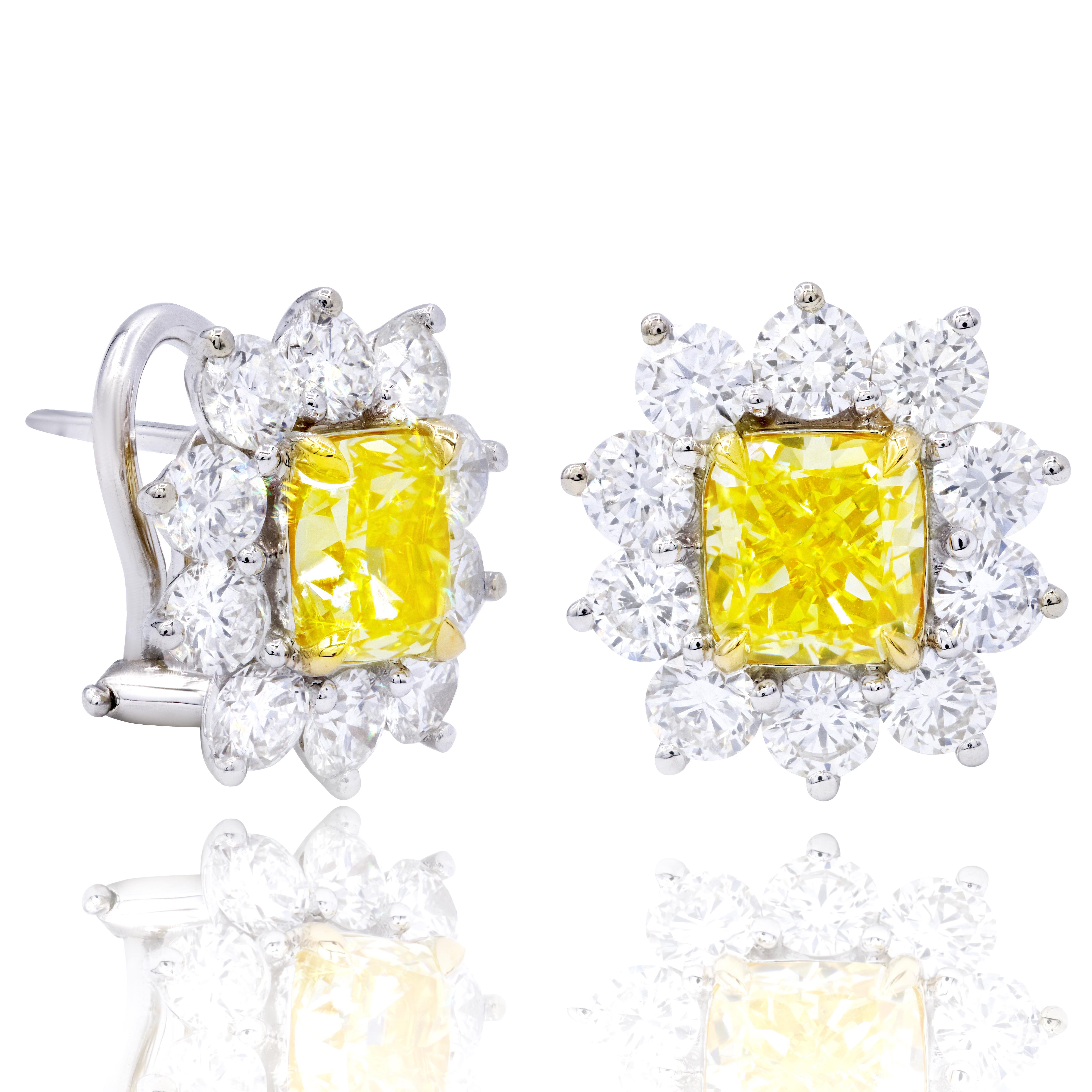 This Beautiful 18kt Yellow and white Gold diamond Earrings features Cushion Cut 1.55 Carats Fancy Light Yellow, VVS2 GIA #6272622866 and Cushion Cut 1.51 carats Fancy light yellow VS1 GIA#6242169214 surrounded by 1.60 carats of large round brilliant