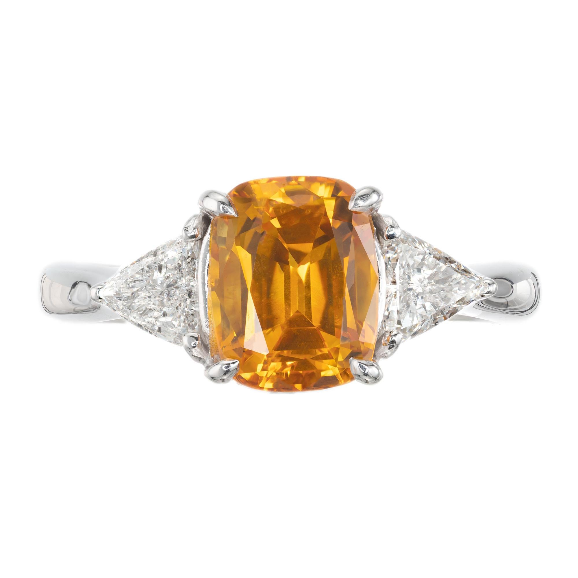 GIA certified yellowish orange sapphire and diamond ring. GIA certified natural cushion cut center sapphire simple heat only in a classic three-stone 14k white gold setting with two triangle shape accent diamonds. 

1 cushion cut yellowish orange