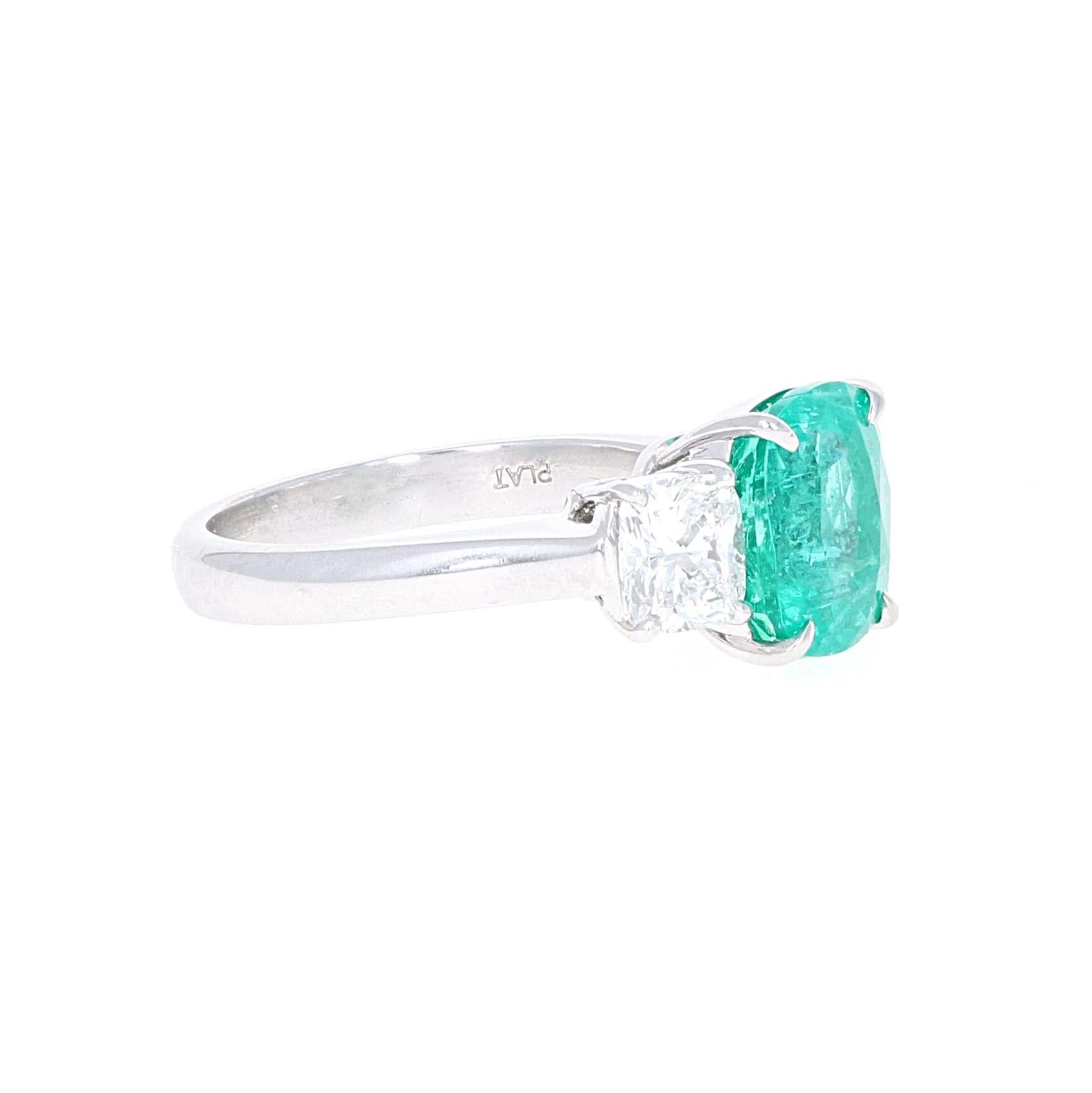 GIA certified, Platinum 3.10 carat cushion cut emerald and diamond ring three-stone cocktail ring. The emerals is a cushion modified brilliant cut. The color is classified as green and is natural beryl. The emerald is Columbian Minor. The treatment