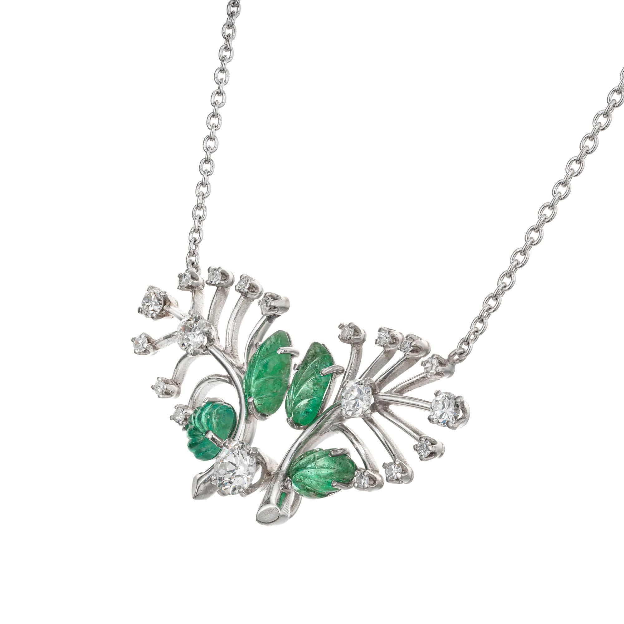 Wonderful 1960's carved bright green Emerald and diamond pendant. 4 carved leaf design emeralds set in a Platinum tree branch style setting with one Old European cut .55ct diamond, accented with 14 round Old European cut diamonds. 19.5 inch chain.