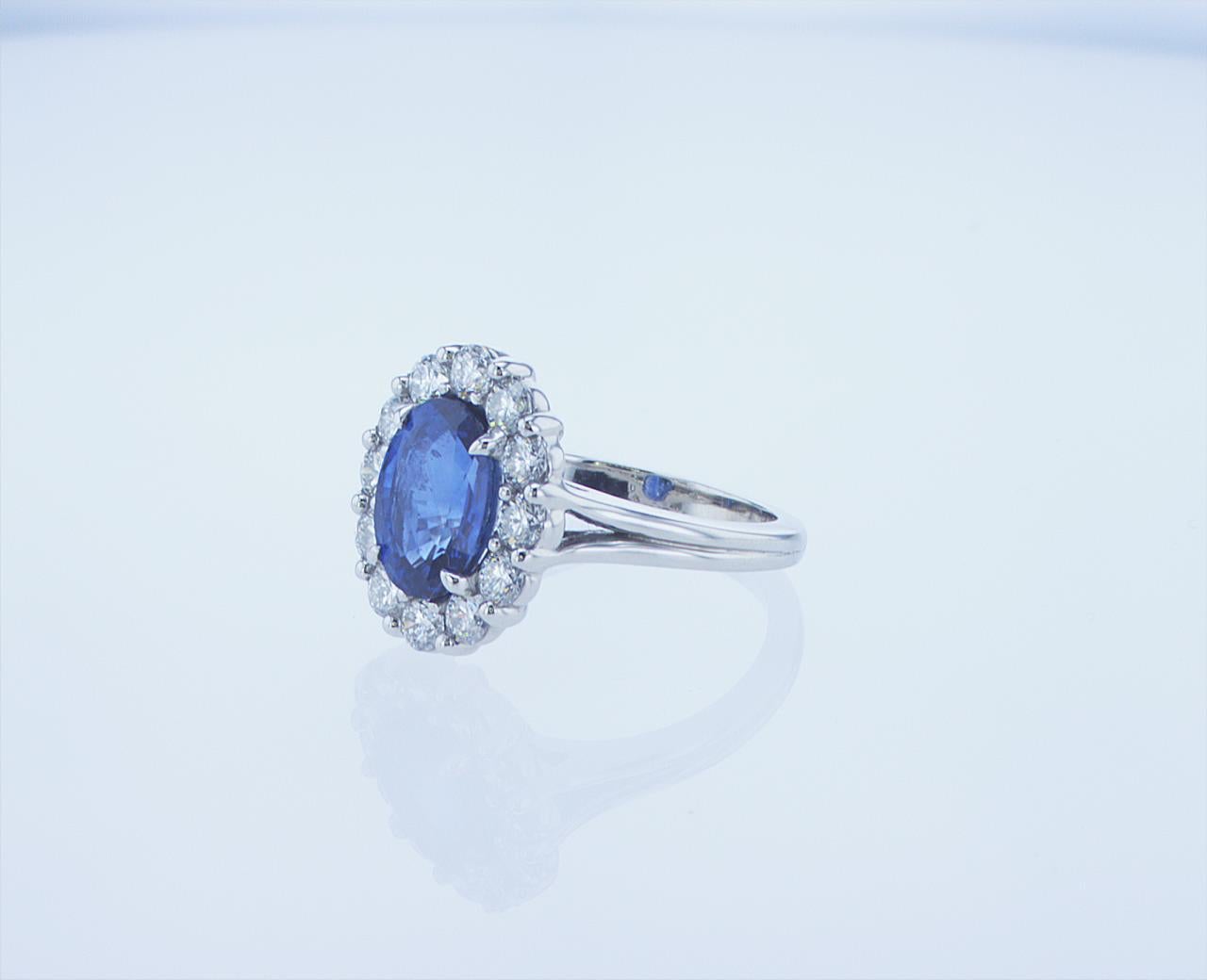 3.13ct GIA Certified Oval Sapphire (GIA Report #2165113056). Featuring 1.02 Carats total weight of G/H Color, VS Clarity Round Brlliant Diamonds around the Oval Sapphire. Plain, Split Platinum Shank.