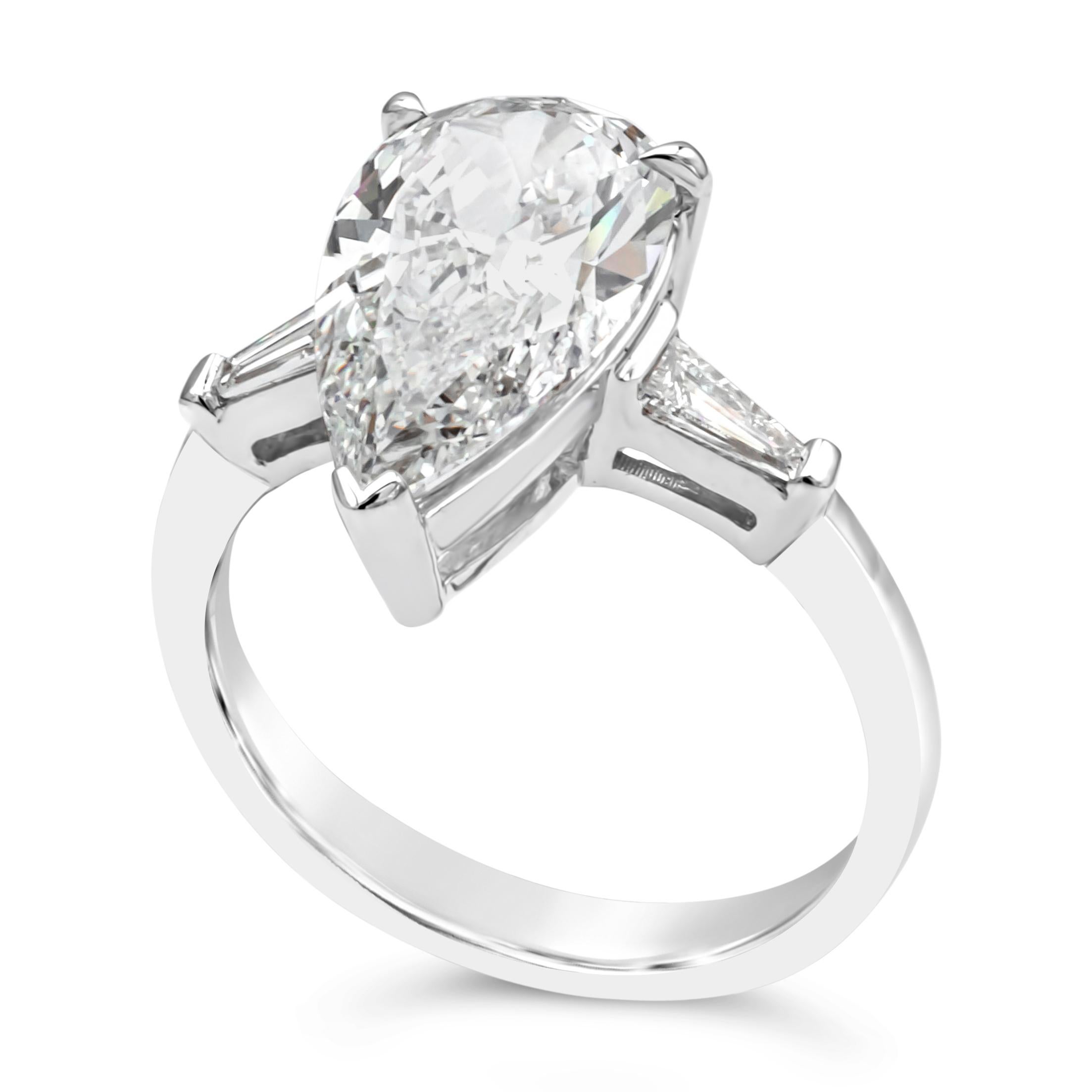 A brilliant and well crafted three stone engagement ring showcasing a GIA Certified pear shape center stone weighing 3.19 carats total, F Color and Si1 in Clarity. Elegantly flanked by tapered baguettes on each side weighing 0.30 carats. Finely made