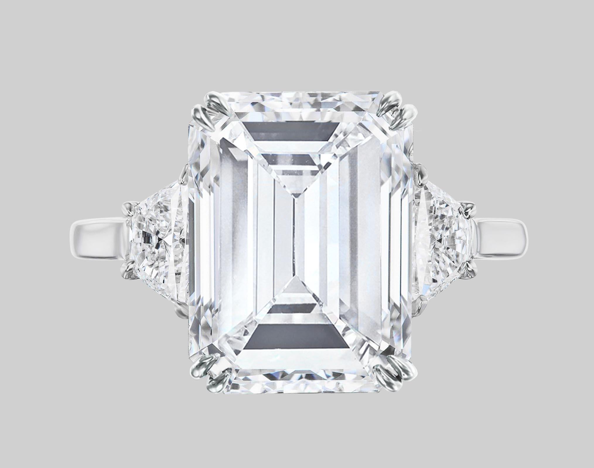 This exquisite ring is the epitome of timeless elegance and precision craftsmanship. At its heart lies a breathtaking 3 carat emerald-cut diamond, boasting an E color grade that exudes a pure and icy brilliance. The stone's VVS2 clarity ensures that