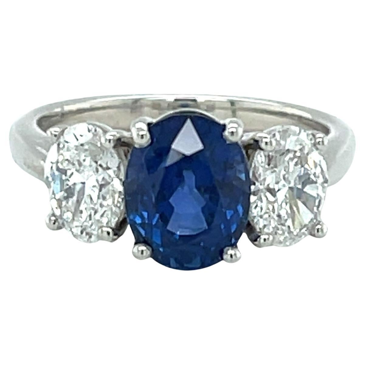 This gorgeous blue sapphire and diamond three-stone ring features a brilliant 3.20 carat oval Ceylon sapphire that has been certified by the GIA as unheated. Most sapphires on the market have been heated to reach this rich, vibrant shade of blue, so