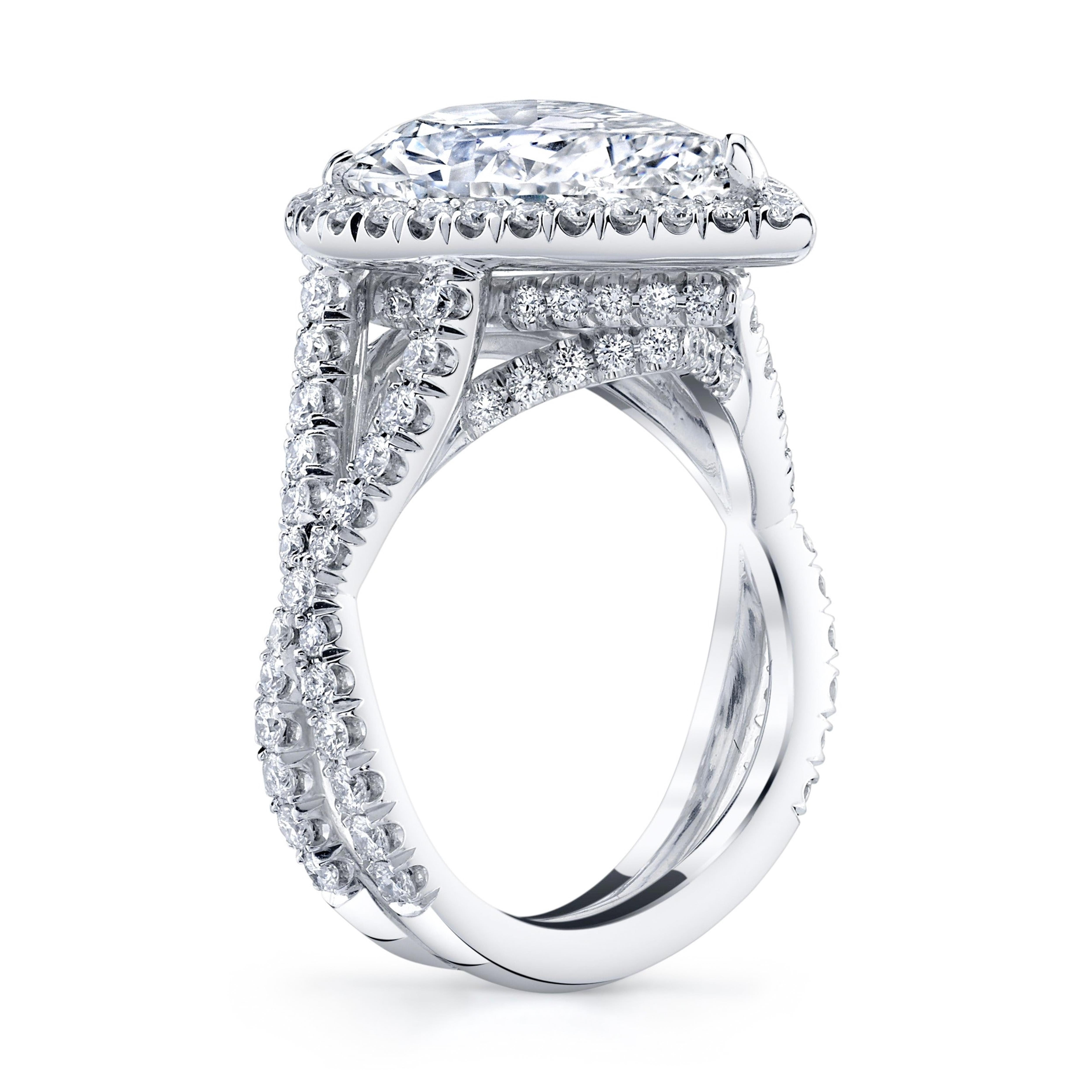 A gorgeous and proportioned 3.21 ct. GIA-certified E color, SI2 clarity, Pear Shape diamond is complemented by an open crisscrossed, double shank encrusted with 115 colorless rounds weighing 1.08 carat total. 
This Platinum ring has a total weight