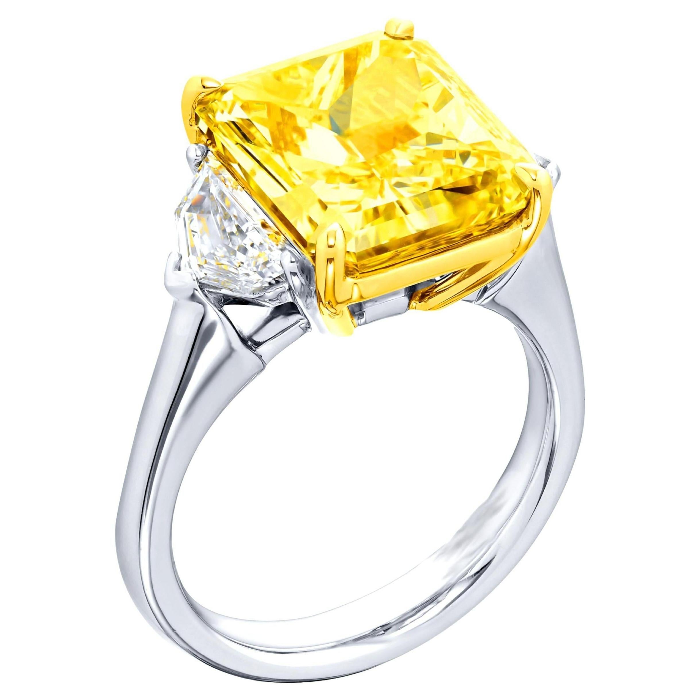 Cette magnifique bague de fiançailles met en valeur un diamant de taille radiant de 3,02 carats certifié par le GIA, d'une teinte jaune intense fantaisie. La pierre centrale est maintenue dans une monture raffinée en or jaune 18 carats qui met en
