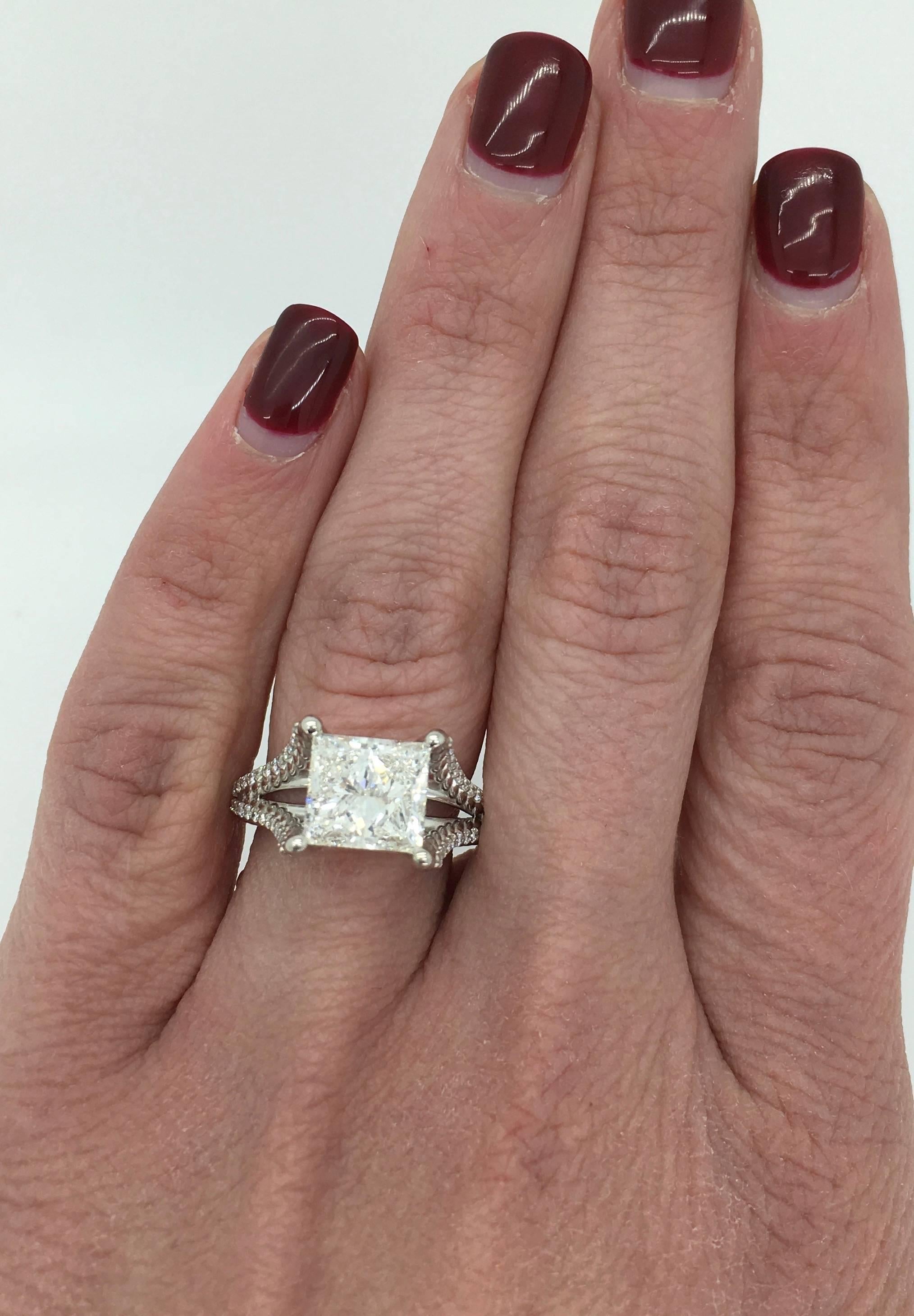 This gorgeous ring features a large GIA certified 3.00CT Princess Cut Diamond. The diamond has I color and SI2 clarity. It is accented by 48 Round Brilliant Cut Diamonds. The total diamond weight is approximately 3.25CTW. The 14K white gold ring is