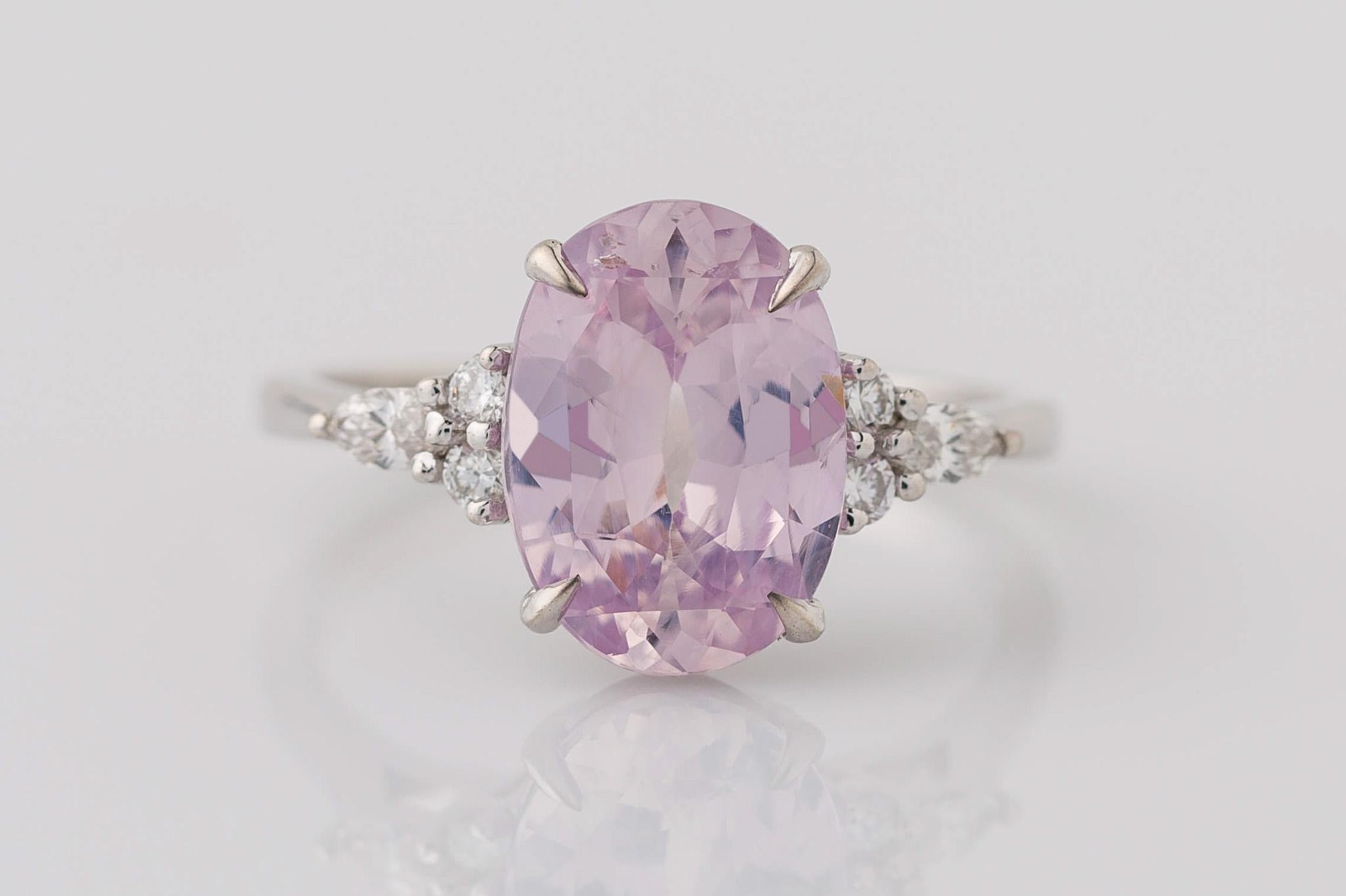 Celebrate your love story with our enchanting GIA Certified Oval Pink Sapphire Engagement Ring, adorned with Cluster Diamonds. The centerpiece is a breathtaking 3.29 carat purple-pink sapphire, all-natural and unheated, measuring 11.08x7.98x4.62mm.