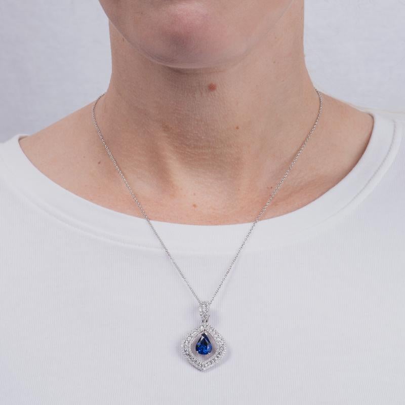 This unique pendant necklace features a GIA certified 3.30 carat pear shaped blue sapphire from Madagascar. The sapphire is floating between 1.64 carat total weight in diamonds. It is set in 18 karat white gold on an 18