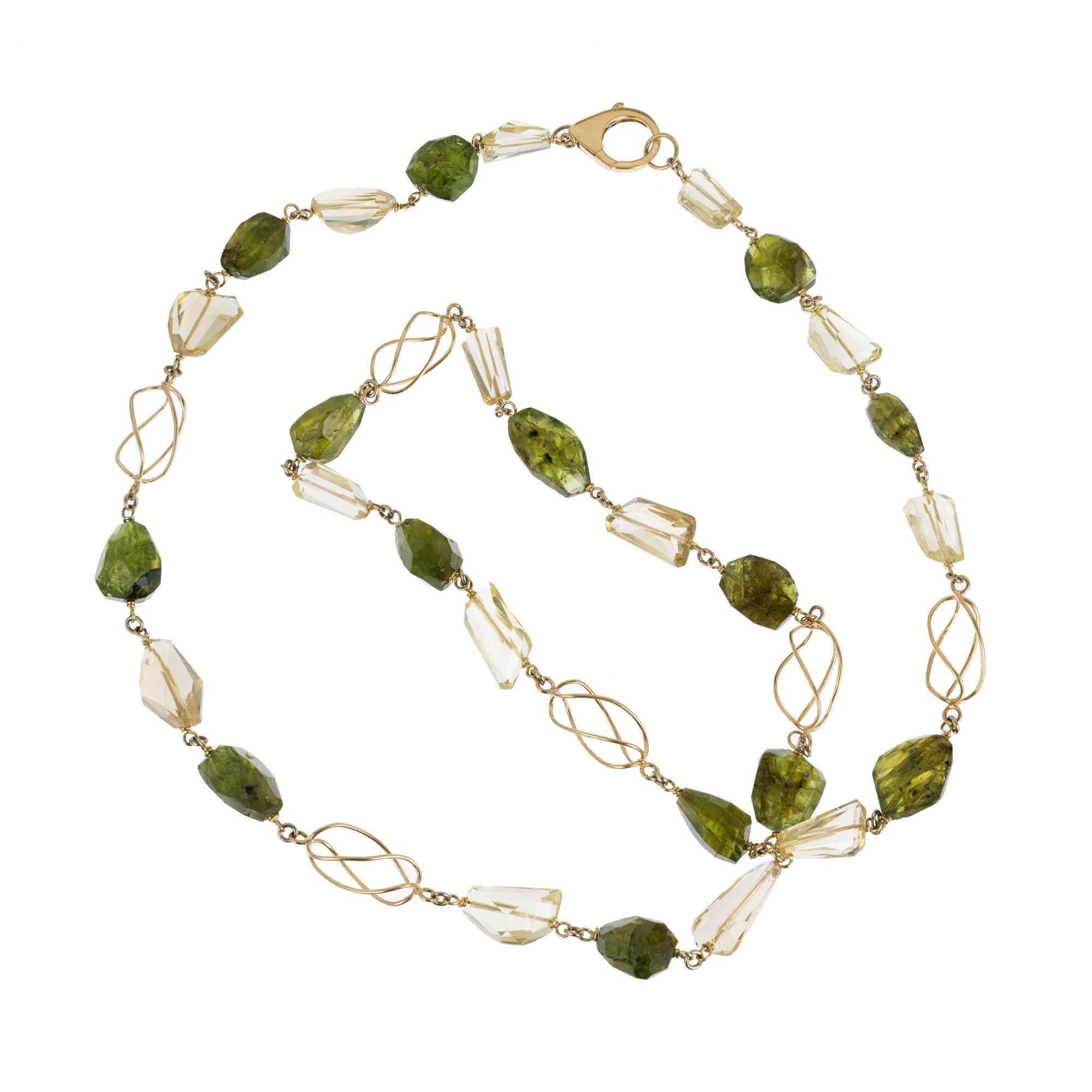 18k yellow gold peridot citrine beaded necklace. Freeform citrine and peridot beads separated by open 3-dimensional 18k yellow gold swirls. Can be worn long or doubled on the neck. Gia certified Peridot 

14 multi-faceted champagne citrine beads,