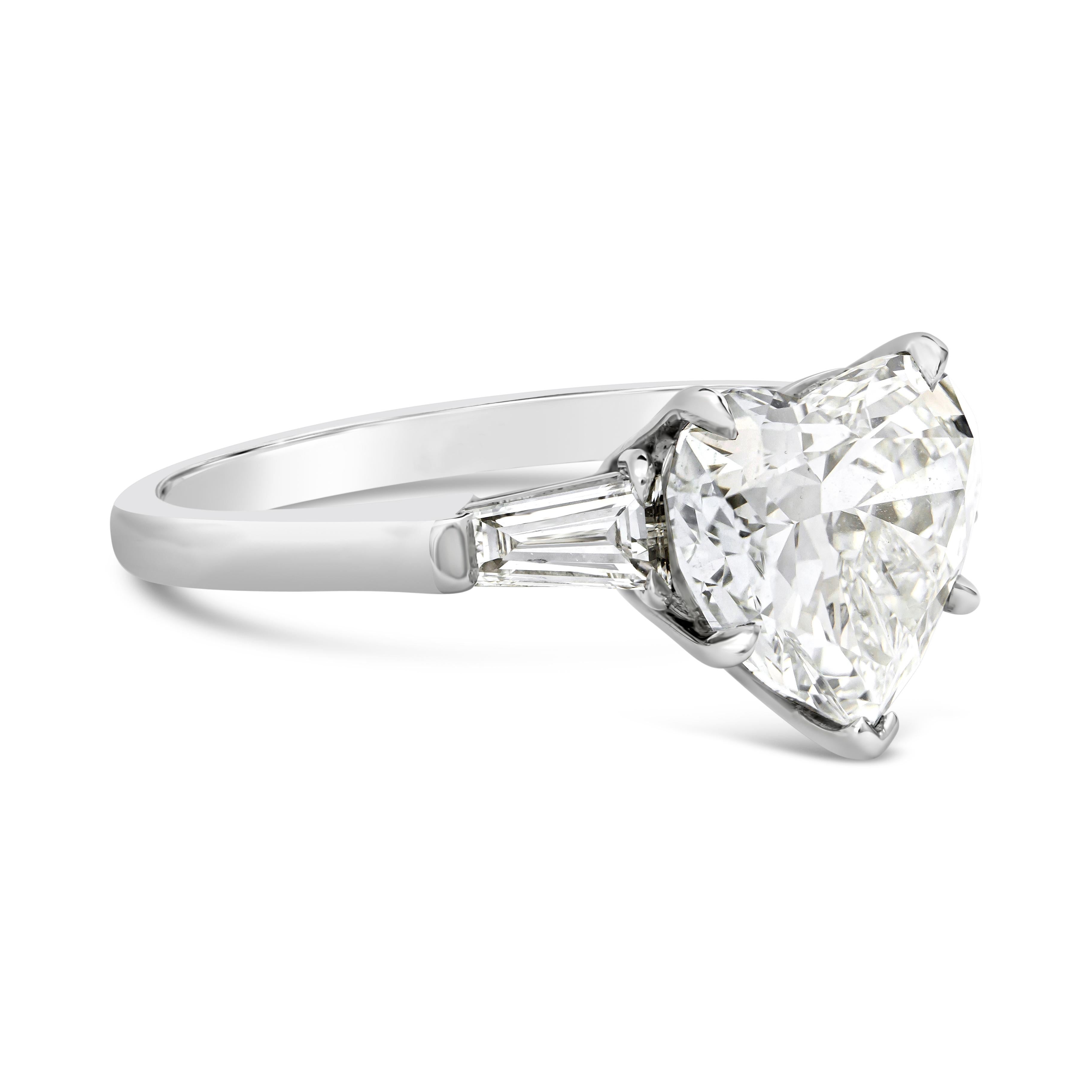 This beautiful and fashionable three-stone engagement ring features a 3.31 Carats Heart Shaped Diamond center stone that GIA certified as K color and SI1 in clarity. Flanked by two baguette cut diamonds on each side weighing 0.57 carats total.