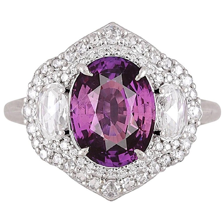 With a GIA Certified 3.31 carat oval cut purple sapphire center, alongside two oval shape white diamonds, this ring shines from every angle. The three center stones are then wrapped in a double halo of round white diamonds. Total diamond weight 0.70