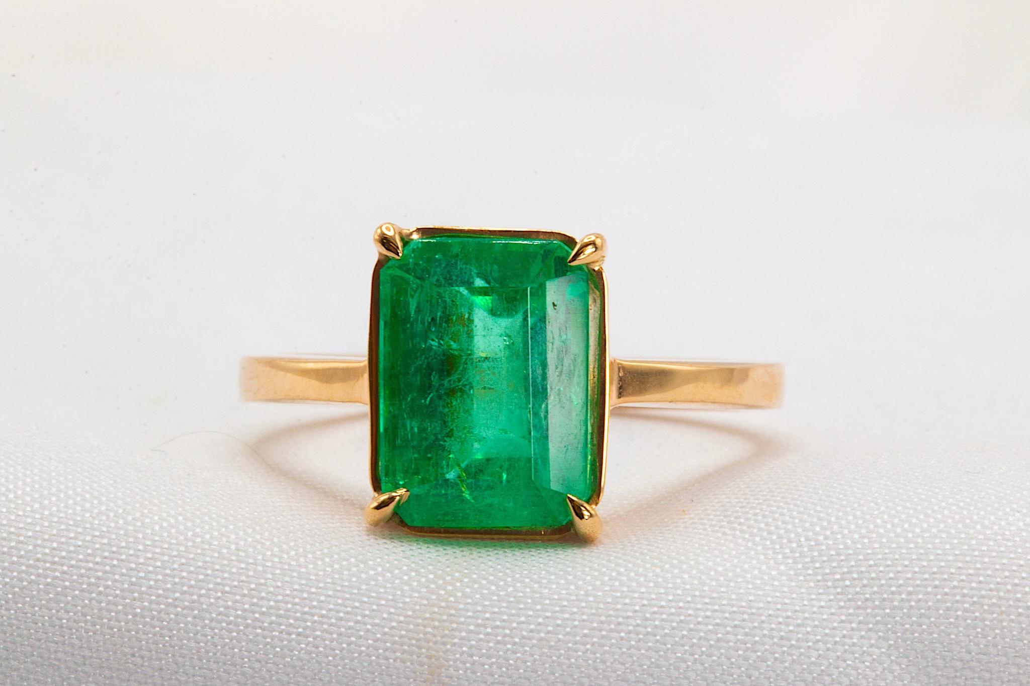 Cette magnifique émeraude colombienne verte taillée en escalier, pesant 3,38 carats, repose dans une monture panier à 4 branches de bon goût, au sommet d'une bague solitaire faite à la main. L'émeraude, qui mesure 10,16 × 7,40 × 5,97 mm, est