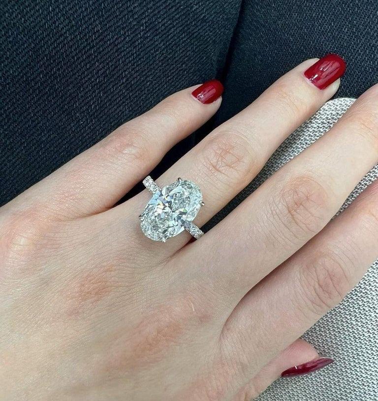 3.40 carat oval diamond, showcasing a breathtaking E color and flawless clarity. Set in solid platinum, this piece is not just jewelry—it's a statement. The surrounding pave diamonds are all E color with VVS clarity, adding an extra touch of