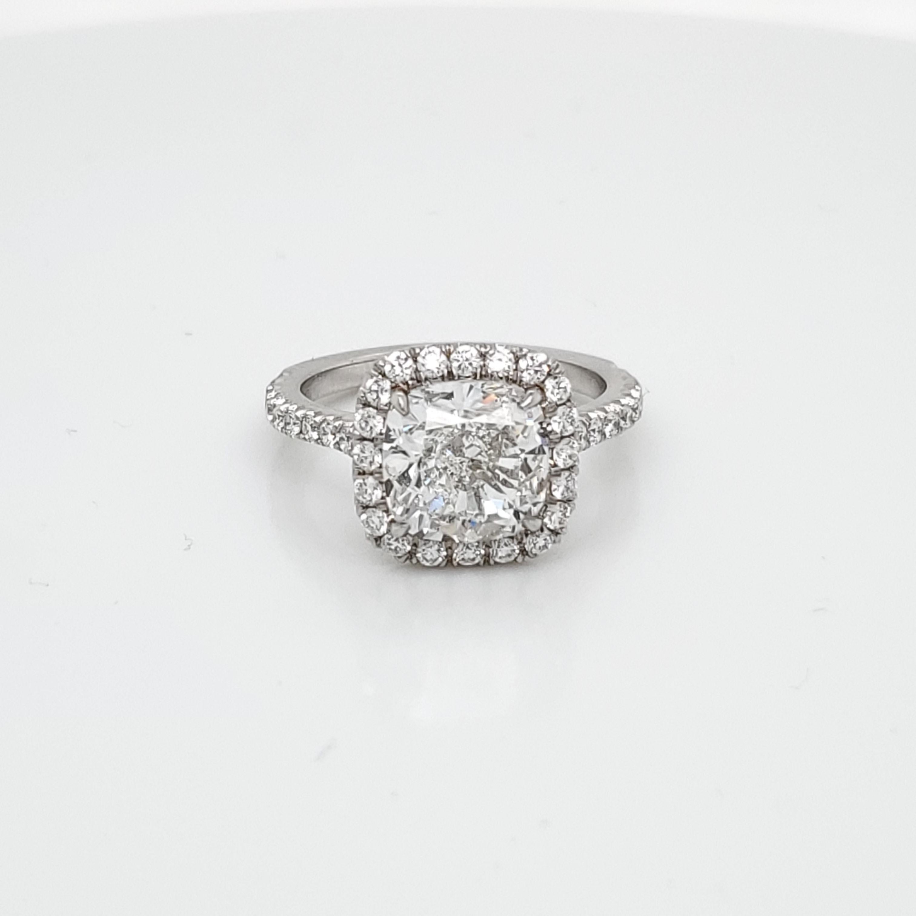 GIA Certified 3.41 Cushion Cut Diamond in Halo and Pave setting. The Center Cushion Diamond is graded F VVS2 and the Diamonds on the setting are VS in quality. There is a total of 0.54 carats on the settings. 