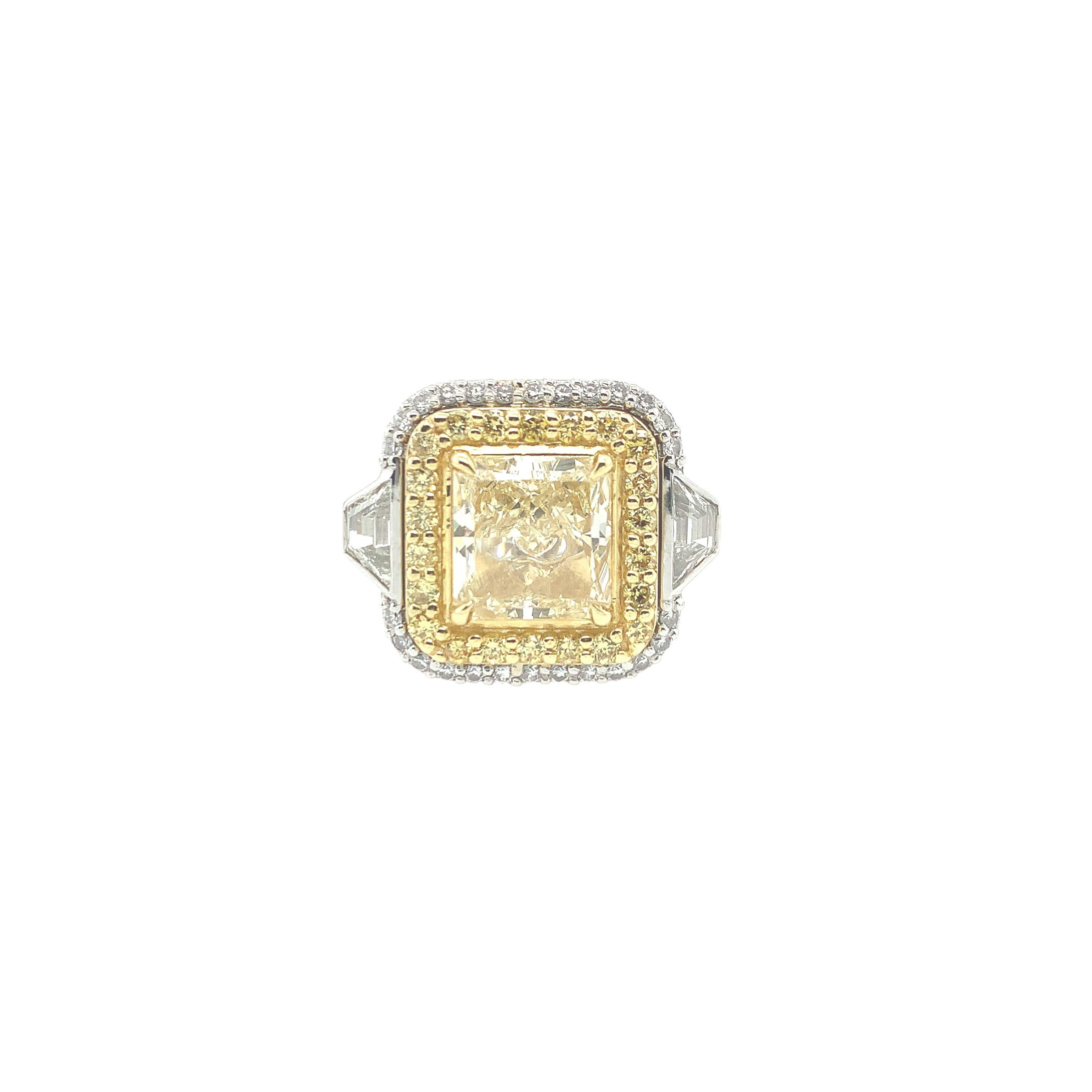 A 3.46 carat fancy yellow diamond is the focal point of this exquisite ring. At its center, this fancy yellow radiant cut diamond measures 8.78 x 8.53 x 5.08mm, VVS2 Clarity.  This magnificent ring is accented by (2) two trapezoids totaling .69cttw