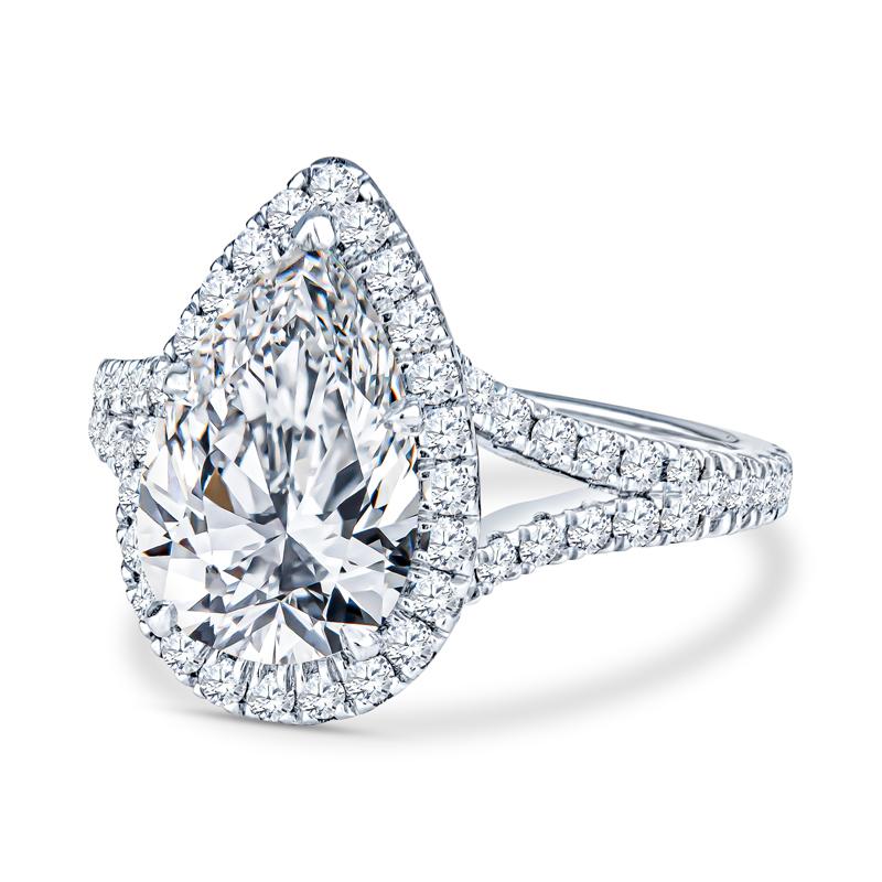 This beautiful ring features a 3.47 carat pear shaped diamond, J VS2, accented by 1.15 carat total weight in round diamonds at the halo and along the split shank band. It is set in 14 karat white gold. This ring is currently a size 8. 
Measurements: