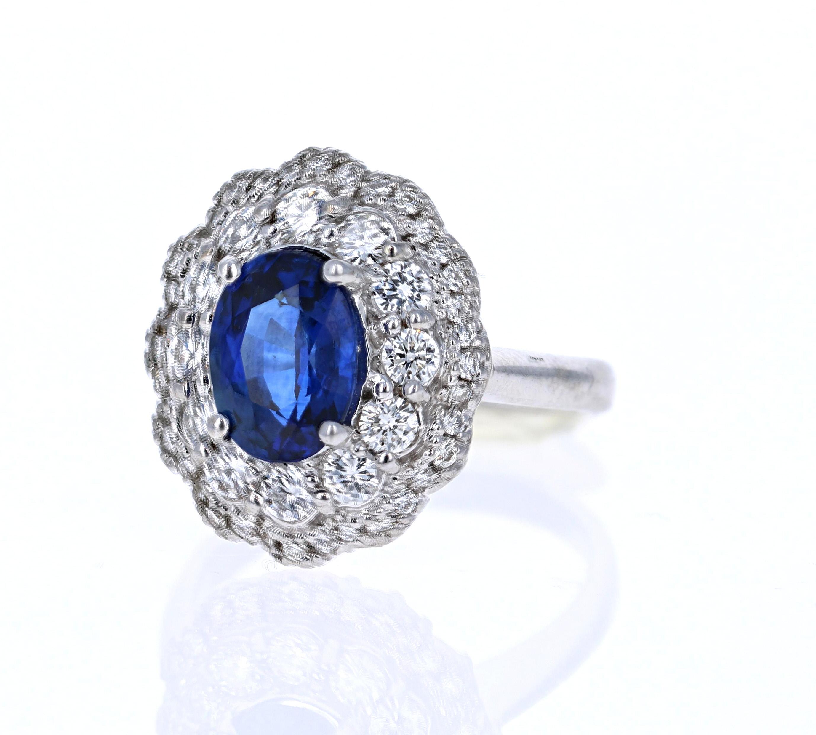 Cette magnifique bague est ornée d'un saphir bleu ovale de 2,33 carats, entouré d'une grappe de 46 diamants ronds de 1,20 carat. Le poids total en carats de la bague est de 3.53 carats. Le saphir est chauffé et est certifié par le GIA. Ses