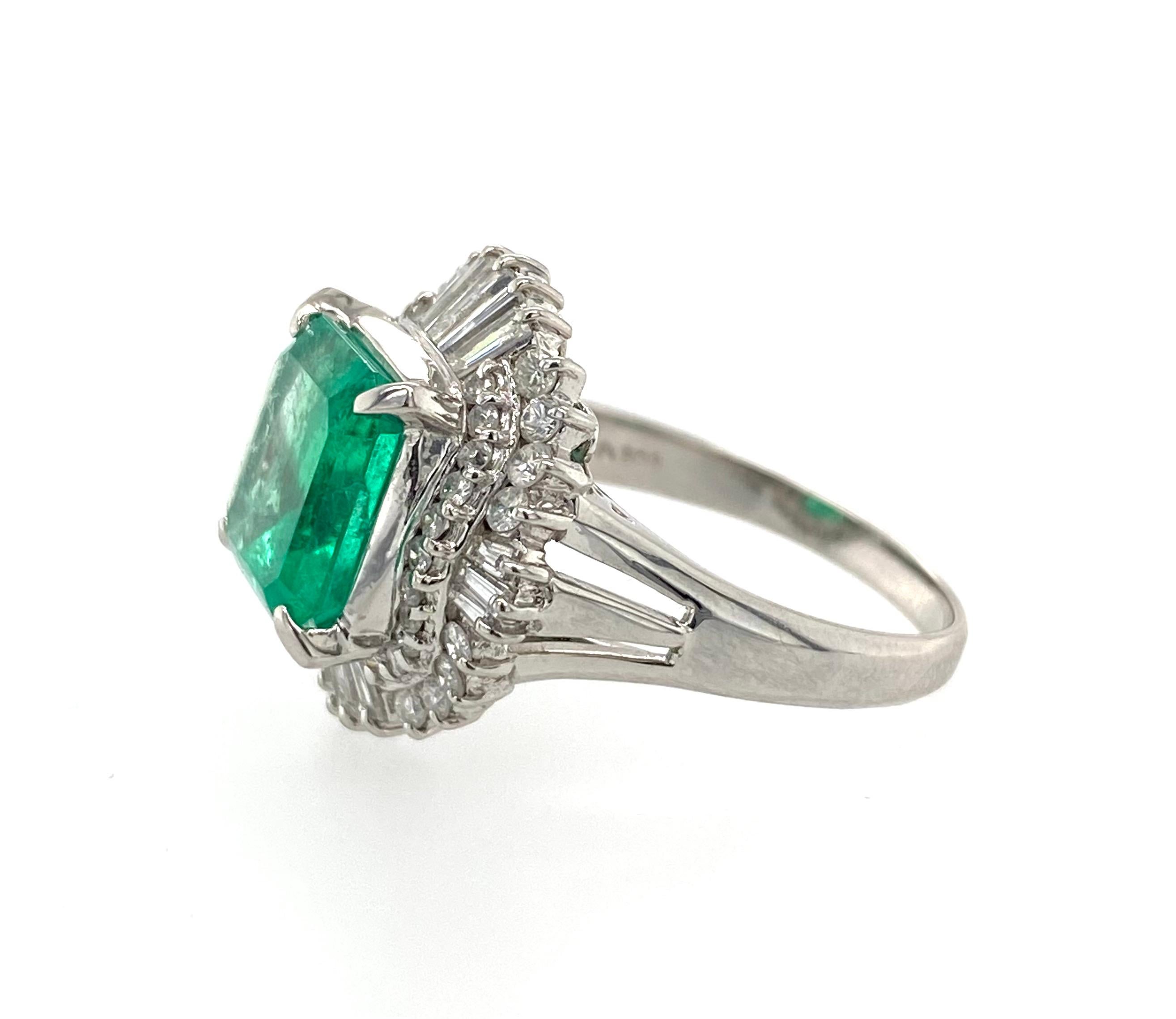 This estate ring is a stunning piece of jewelry that features a 3.53 carat Colombian emerald as its centerpiece. The emerald is set in a platinum band and is accompanied by 0.95 carats of sparkling diamonds. The combination of the rich green emerald