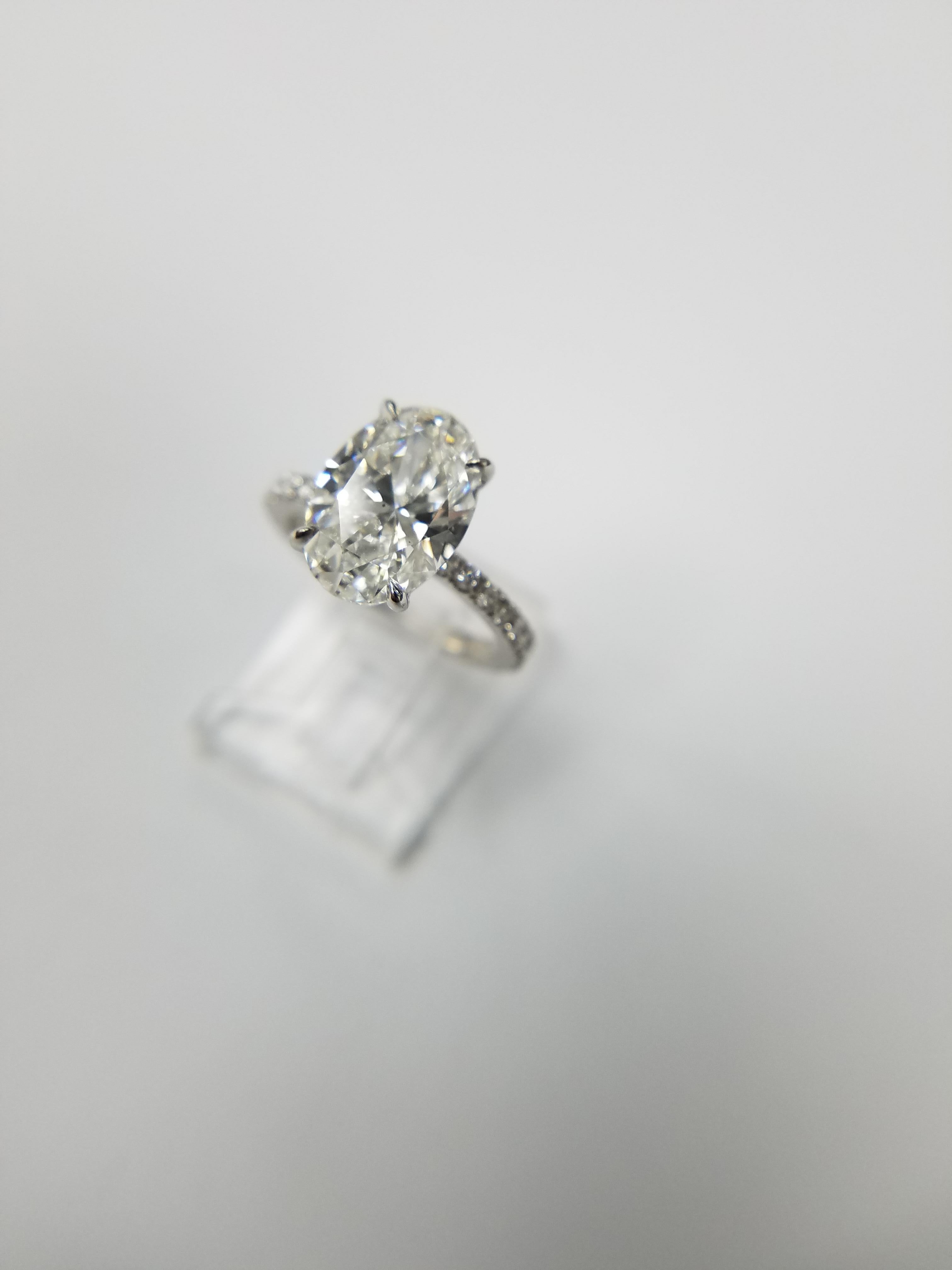 This is a classic ring which you can never go wrong with. Center stone is a 3.55 carat Oval Cut Diamond E color and VS2 clarity. GIA report number 2195563721. The center stone is set in a Platinum micro pave setting with 0.38 carats of white round