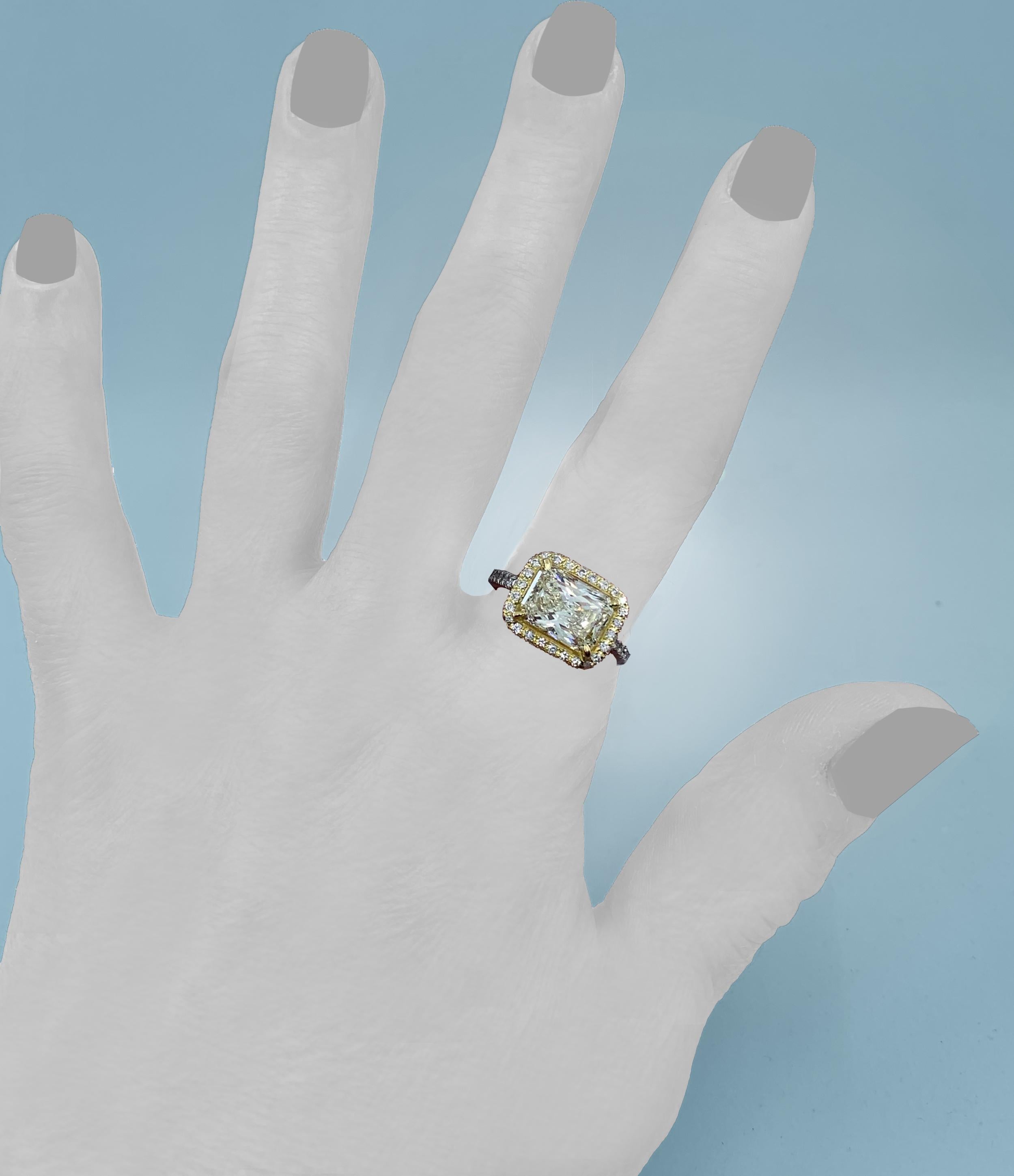 Eytan Brandes made the gorgeous mounting that perfectly showcases this clean, natural and untreated light yellow diamond.  

The prongs and frame are in 18 karat yellow gold to accentuate the stone's pale yellow hue;  the strong yellow of the frame