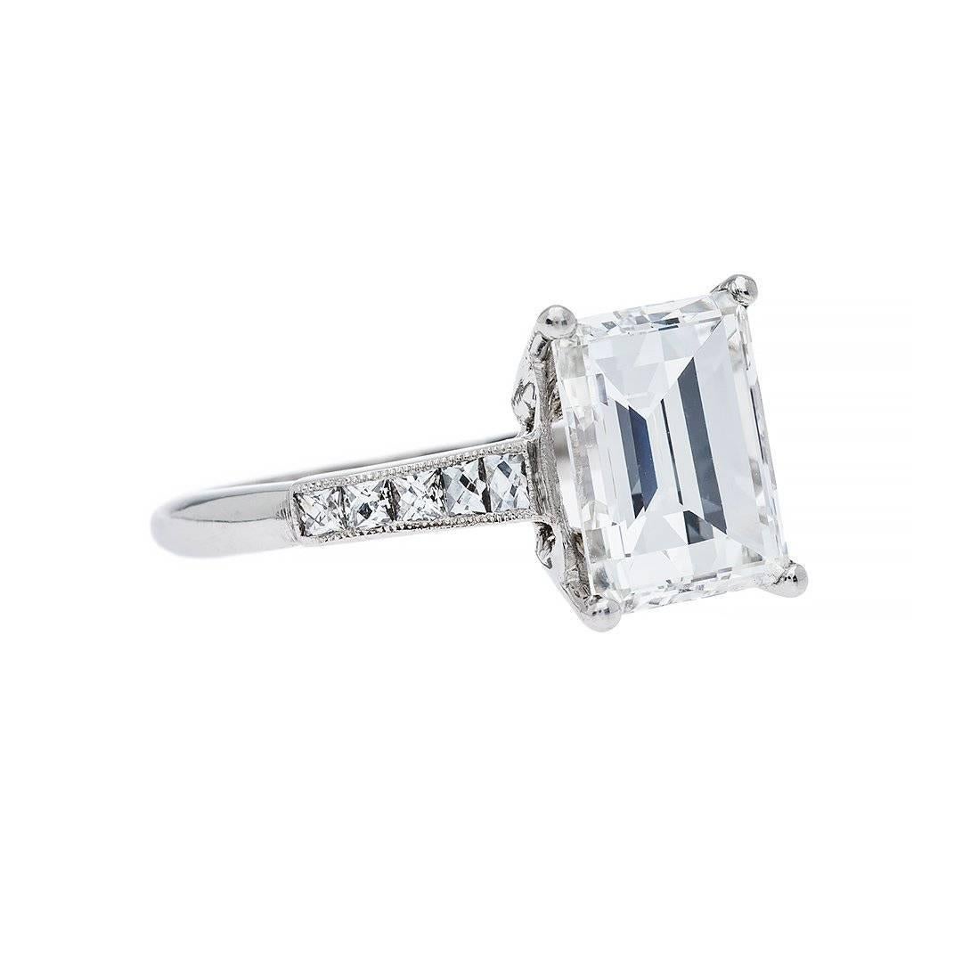 Divine beauty through traditional standards. Featuring a 3.56 carat emerald cut diamond that has been GIA graded as G color, VS2 clarity. Perfectly accented by 10 french cut diamonds weighing approximately 0.40 carats that cascade down the hand made