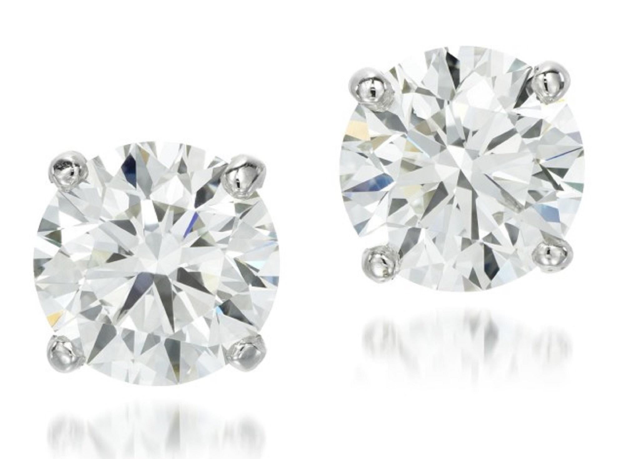 This striking GIA Certified 4 carat pair of round brilliant cut certified diamonds is bright white, eye clean, and dazzlingly brilliant! These diamonds were individually hand selected for their superior color, well hidden inclusions, and beautiful,