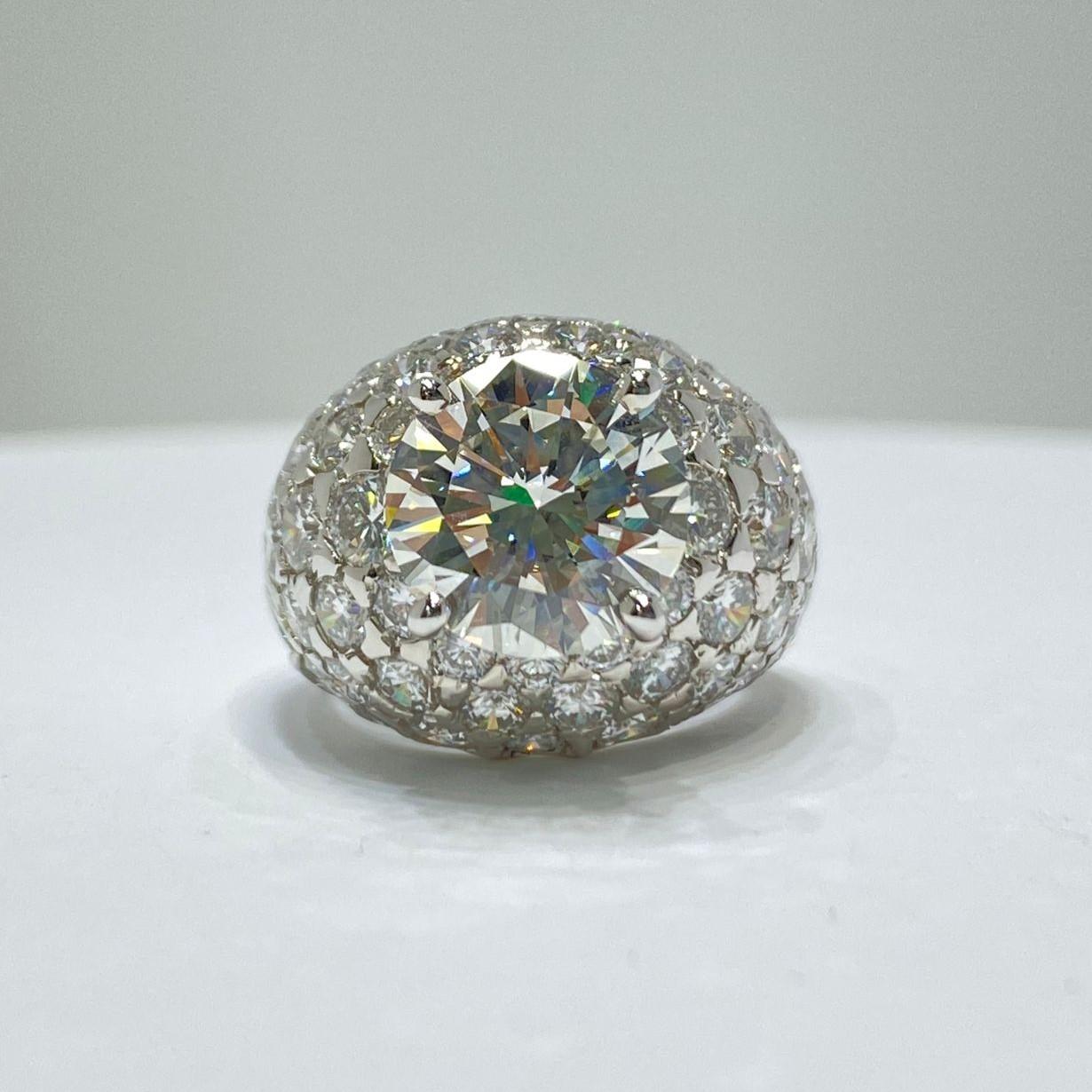 Dieser Ring für den kleinen Finger ist einfach elegant und schön. Der Mittelstein ist I Farbe, VVS2 Klarheit. Der runde 3,67-Karat-Diamant funkelt, während die kleineren 64 runden Diamanten um ihn herum perfekt aufgereiht sind, um den größeren