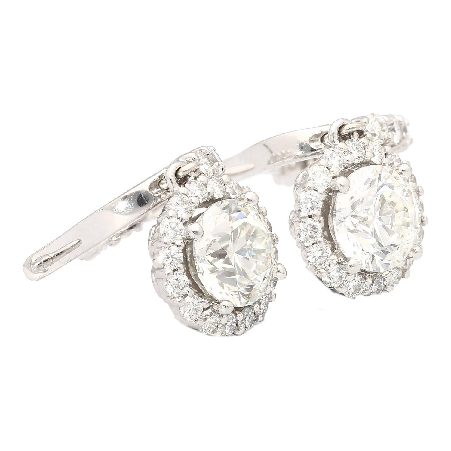 18k White Gold Diamond Dangle-Drop Earrings, a luxurious and elegant accessory. Each earring showcases a 1.53 carat GIA certified center stone, adorned by a round cut diamond halo. Designed with a latch back closure and secure hoop wire connection,