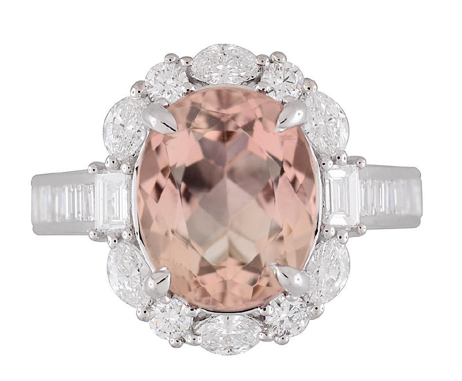 Deléitate con el impresionante encanto de este anillo cautivador, una exquisita obra maestra destinada a adornar la mano de un entendido exigente. En su corazón yace una fascinante Turmalina Rosa Naranja de Corte Ovalado de 3,76 quilates certificada