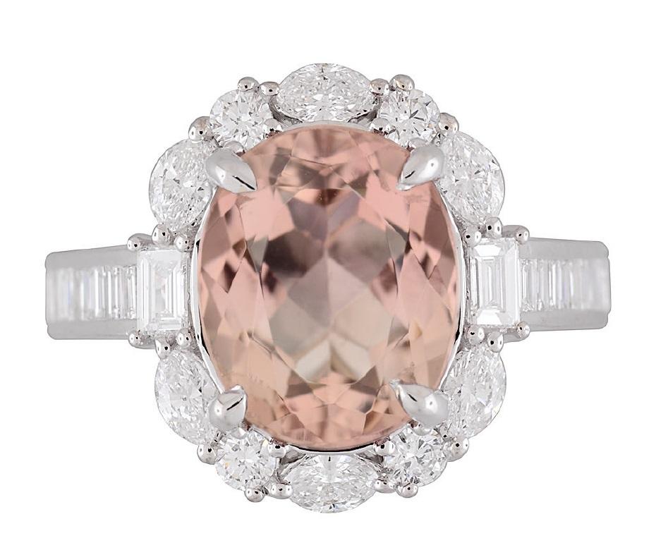 Indulge in the breathtaking allure of this captivating ring, an exquisite masterpiece destined to adorn the hand of a discerning connoisseur. At its heart lies a mesmerizing GIA-certified 3.76 Carat Oval Cut Orangy Pink Tourmaline, a rare gem of