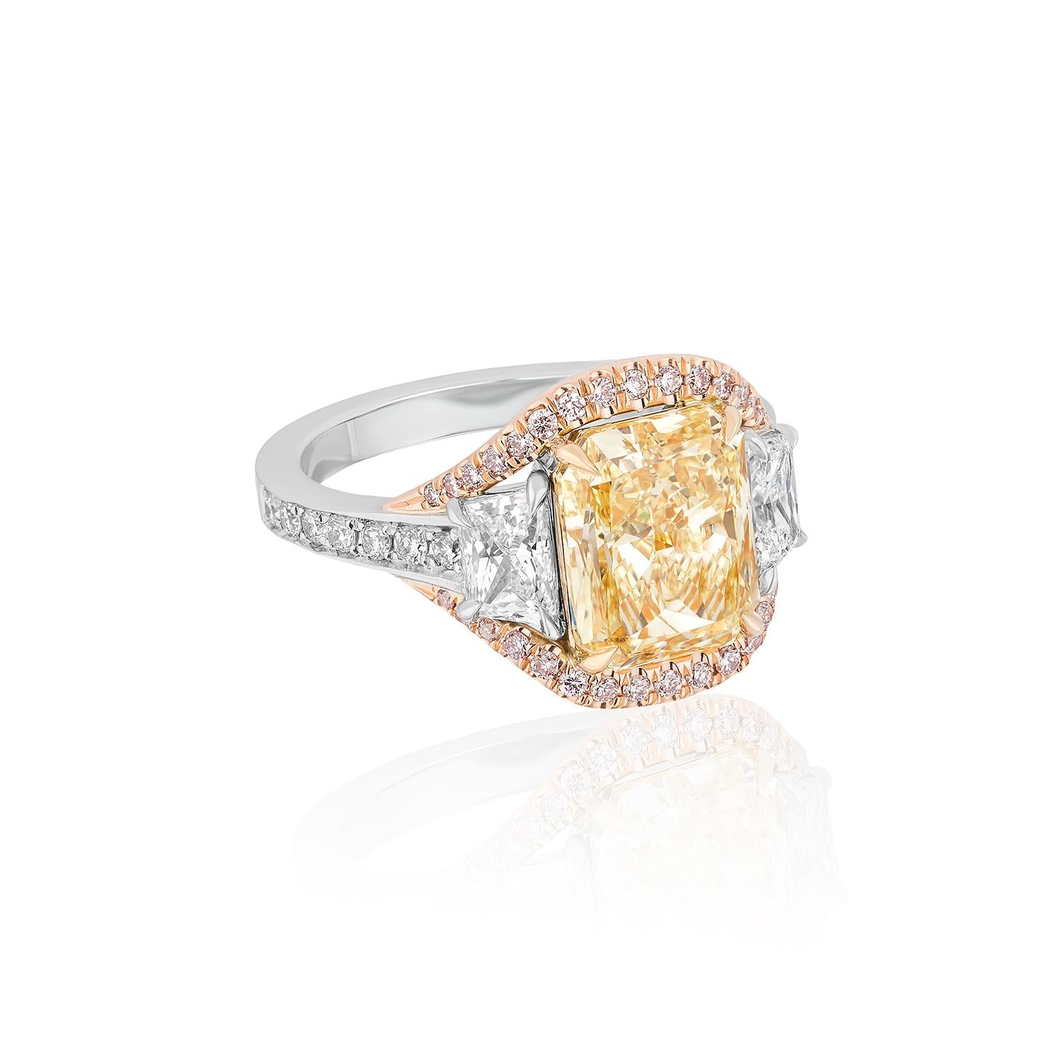 Zentriert auf einem 3,77 Karat Radiant-Schliff, flankiert von trapezförmigen Diamanten und rosa Diamanten auf der Oberseite Motiv-Design.
Weiße Diamanten auf dem Schaft.

Mittelstein mit einem Gewicht von 3,77 Karat, zertifiziert von GIA als Fancy
