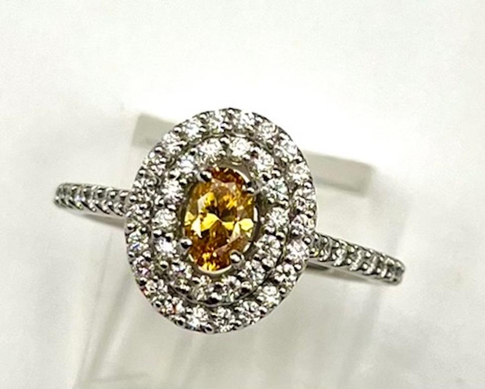 Contemporary GIA Certified .37Ct Oval Natural Fancy Vivid Yellow-Orange Diamond Ring For Sale
